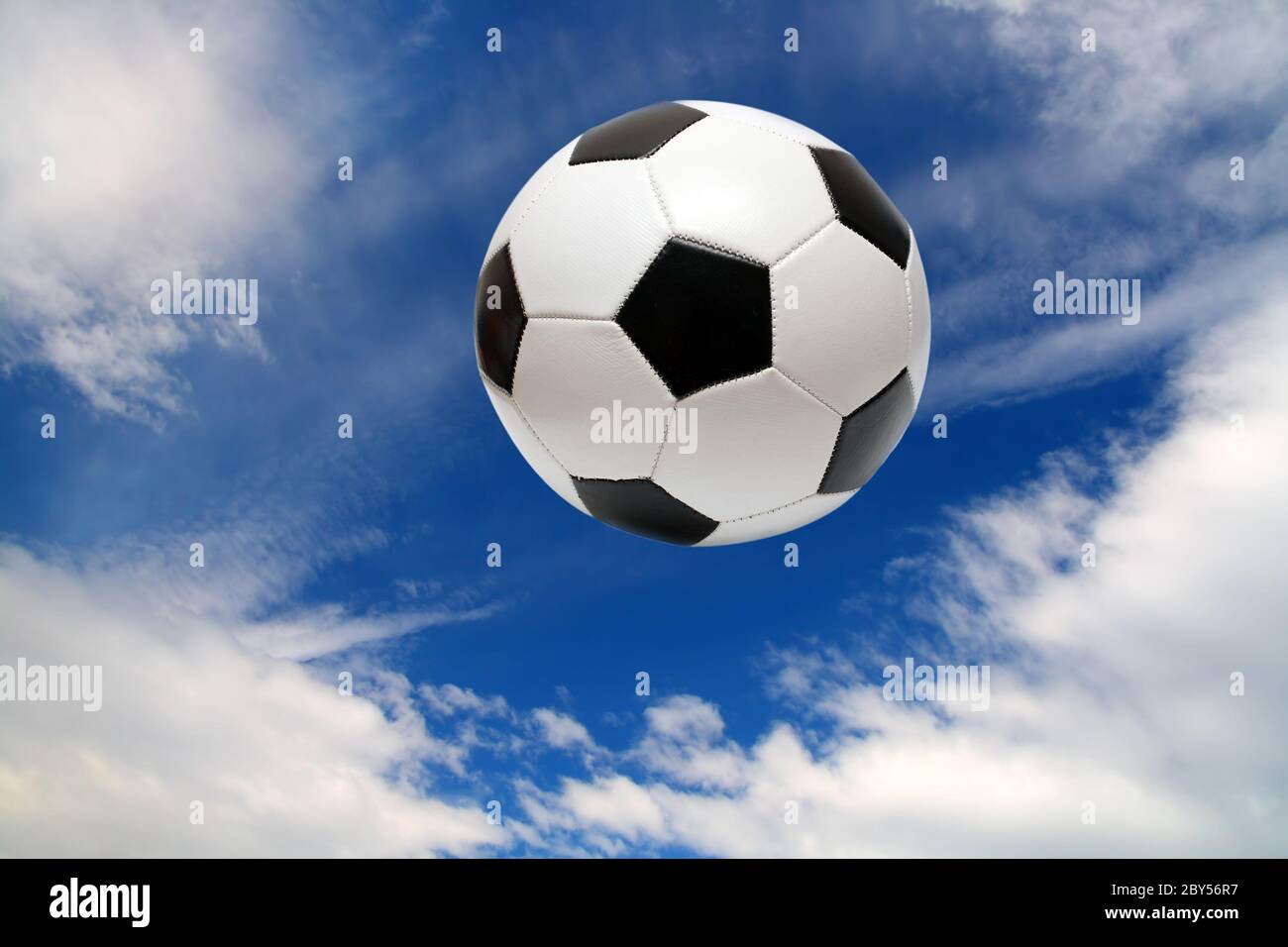 Horizontal image of soccer ball being kicked by footballer against blue sky  Royalty-Free Stock Image - Storyblocks