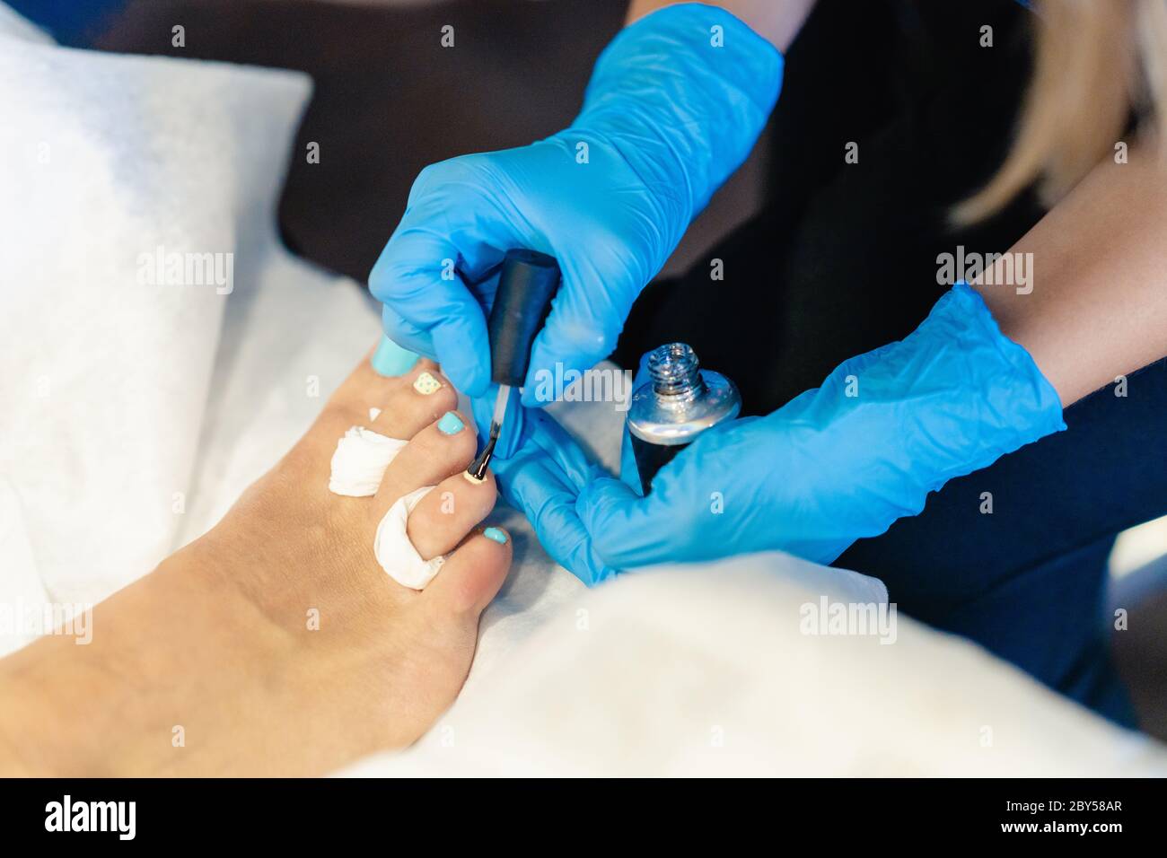 Beautician giving a pedicure painting her client's nails in a beauty centre. Business and beauty concepts Stock Photo