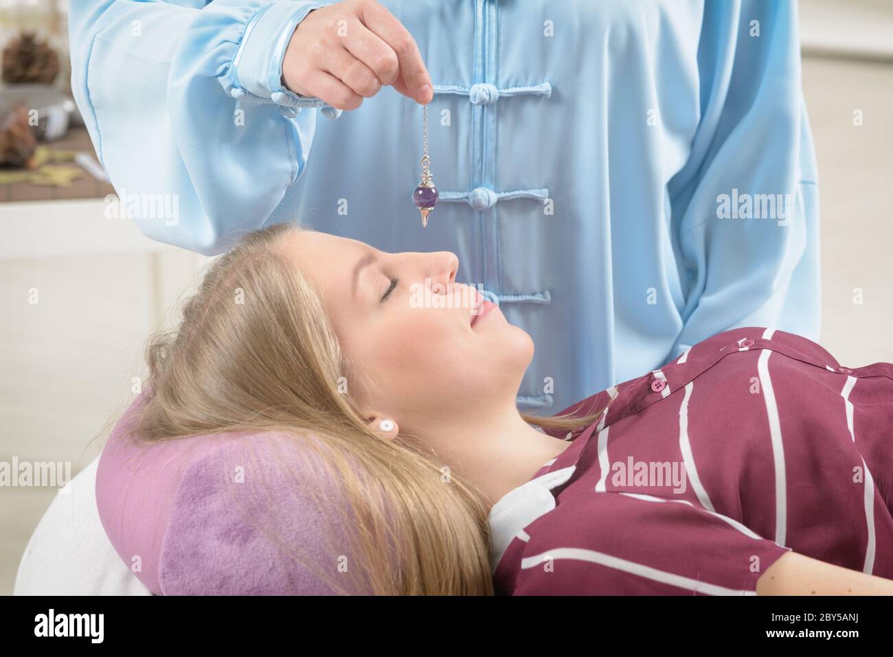 Alternative medicine therapist using pendulum to make a diagnosis Stock