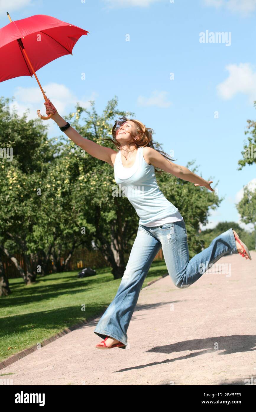 smiling girl jumping with red umbrella Stock Photo - Alamy