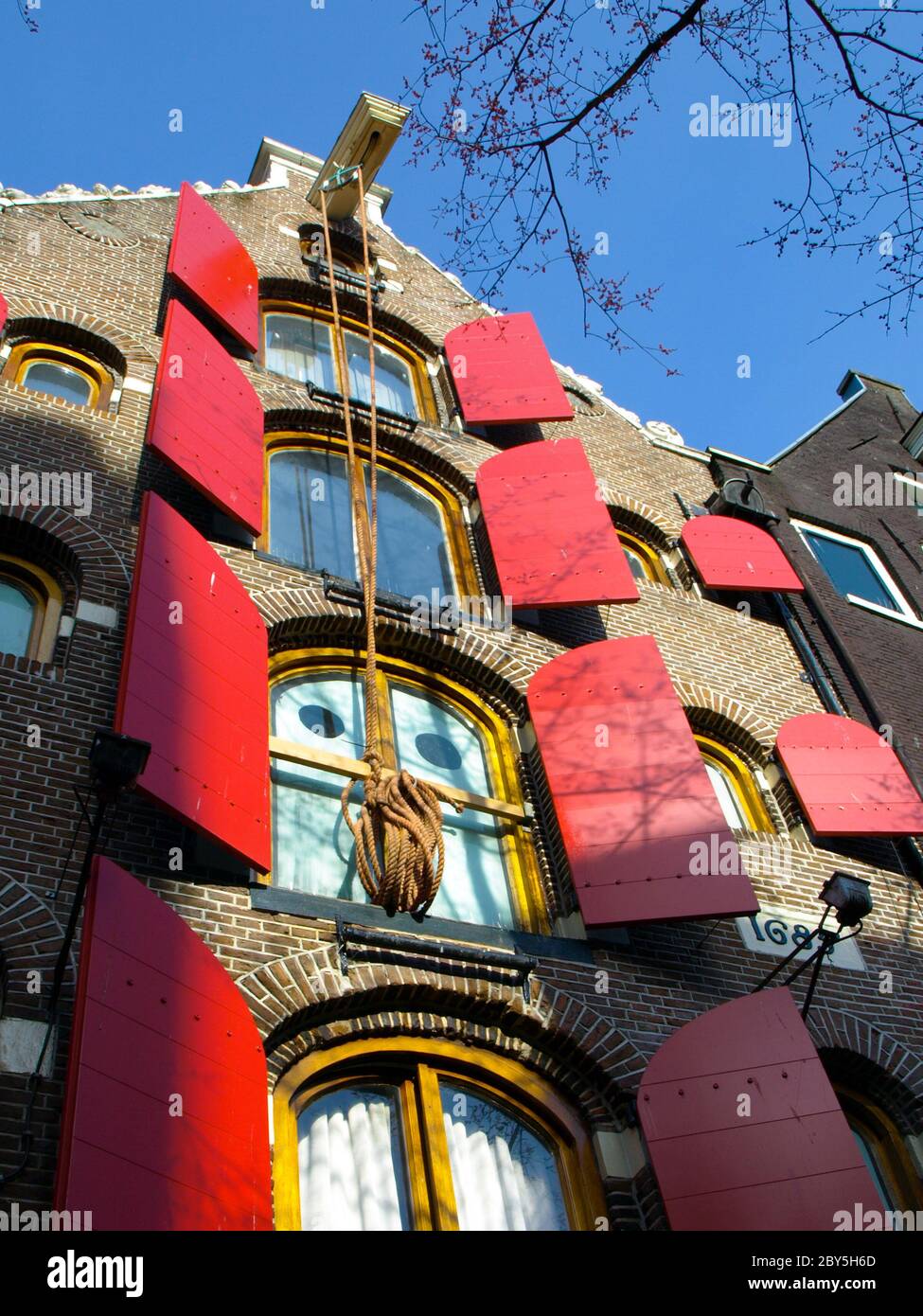 Amsterdam house with red window shutters and rope hanging on the hook