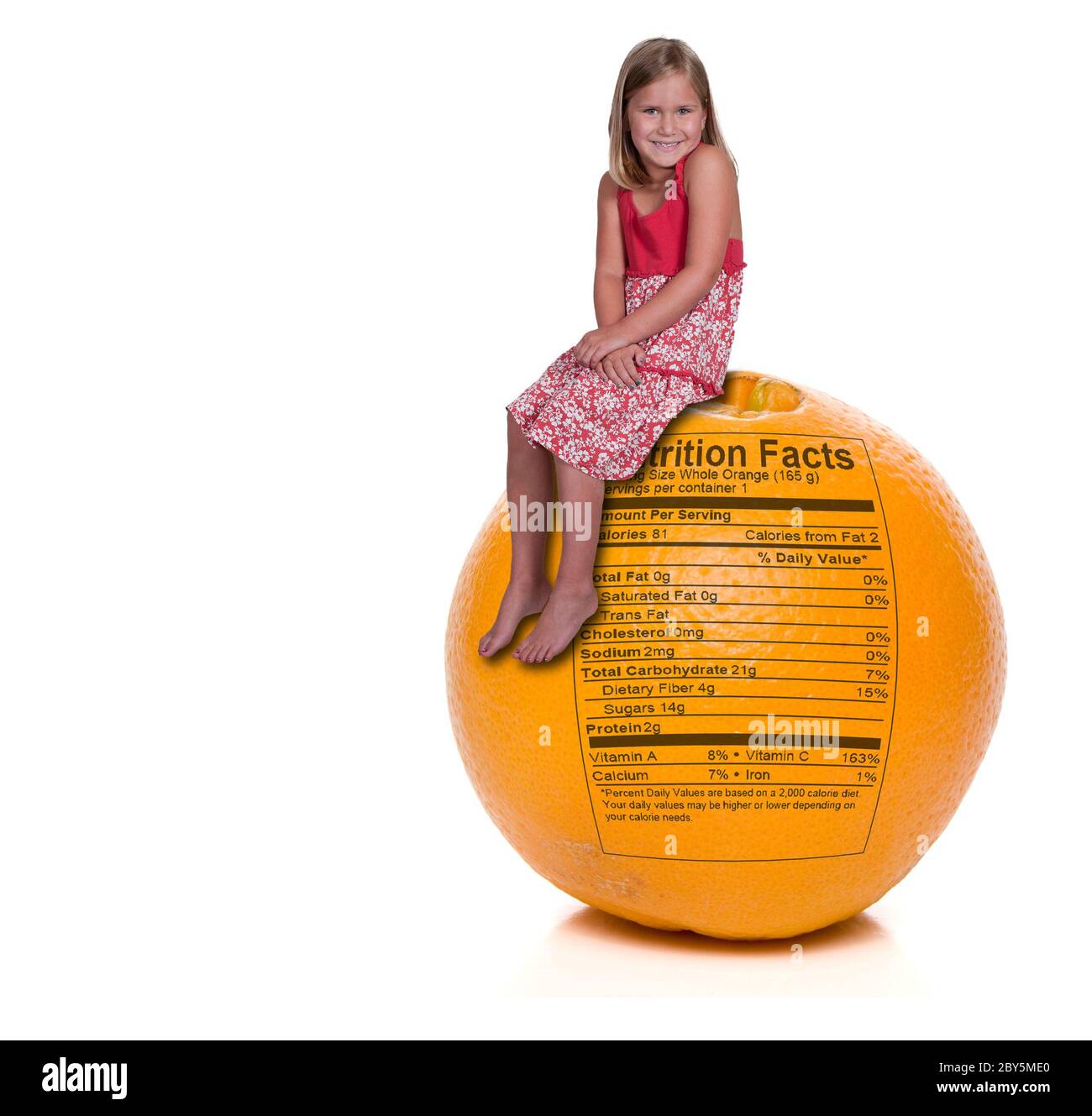 Girl Sitting on Orange with Nutrition Label Stock Photo