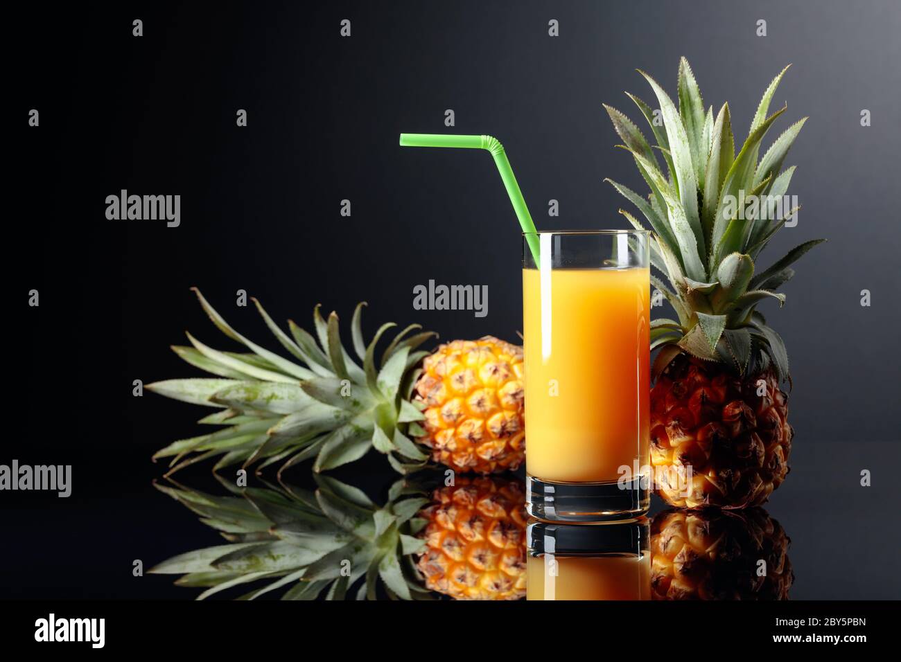 Fresh pineapple juice on a black background Stock Photo - Alamy