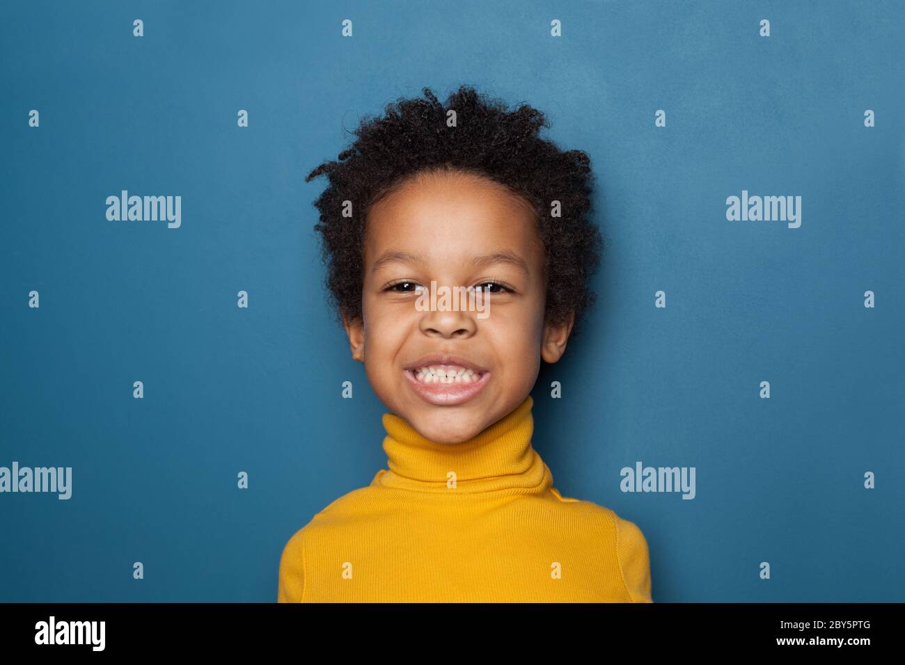 Funny black kid boy on blue background portrait Stock Photo