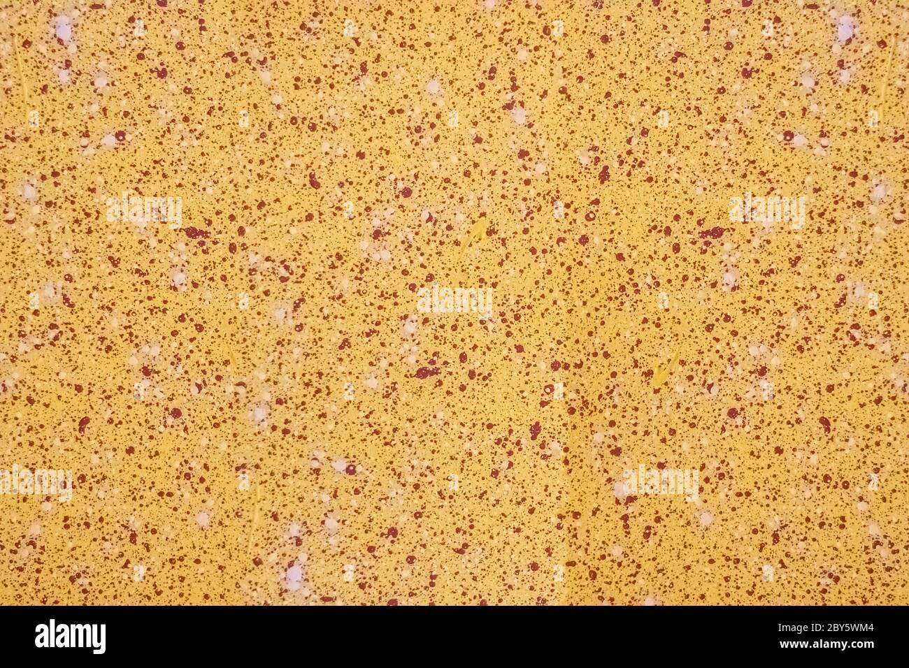 Wall surface with red and pink splashes on a yellow background. For use as an abstract background. Stock Photo