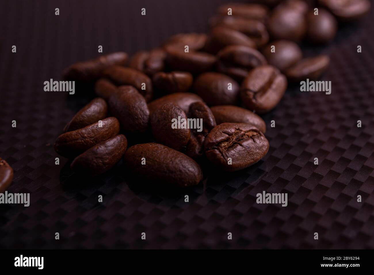 Roasted brown coffee beans on black carbon table or dark background ...