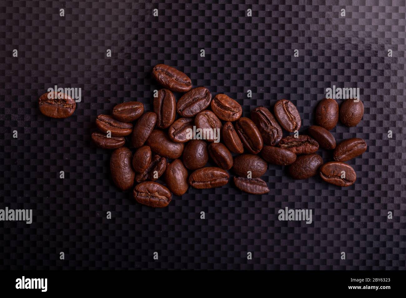 Roasted brown coffee beans on black carbon table or dark background ...