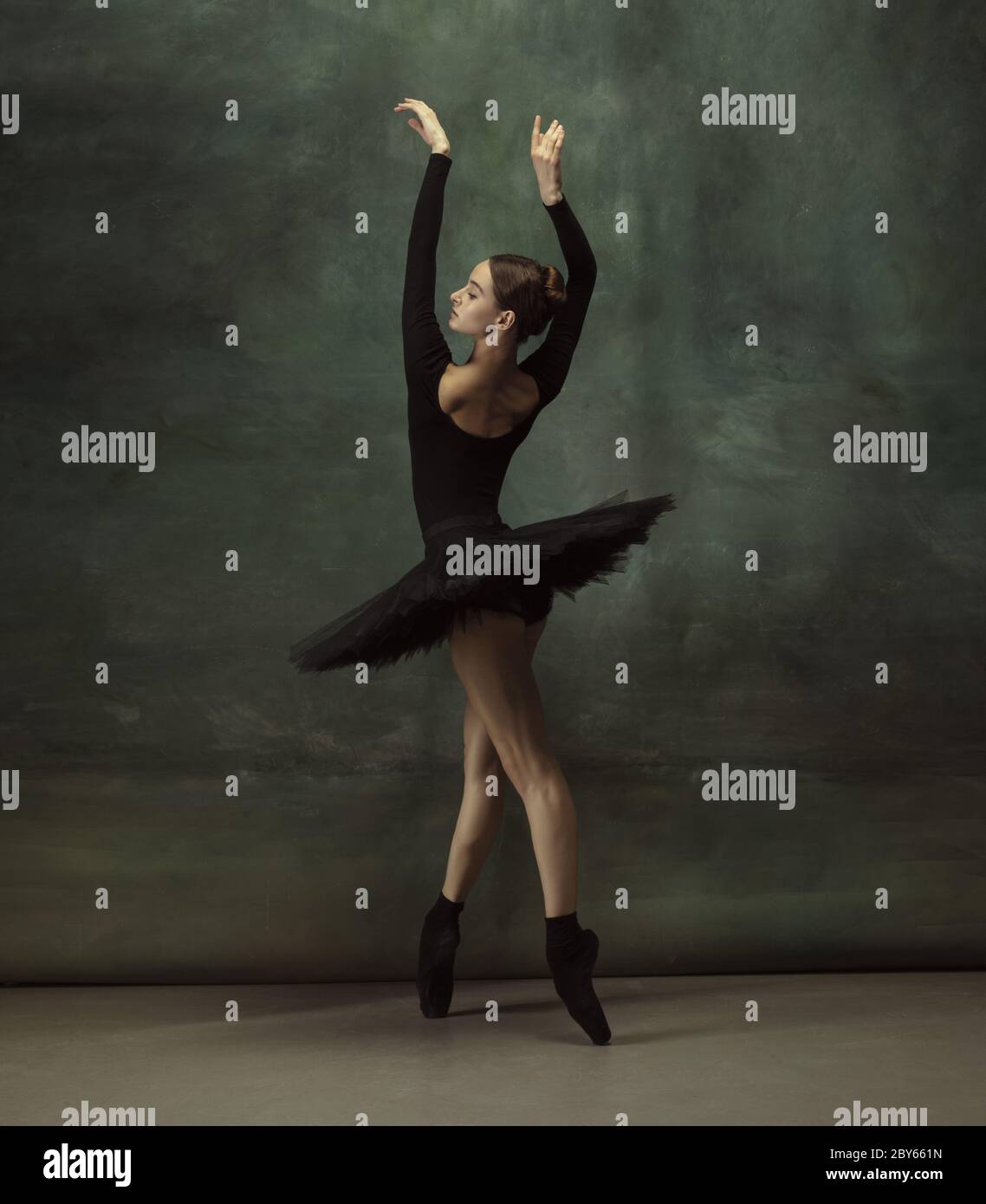 graceful ballerina in black swan dress against white background. Young  ballet dancer practicing before performance in black tutu, classical dance  stud Stock Photo - Alamy