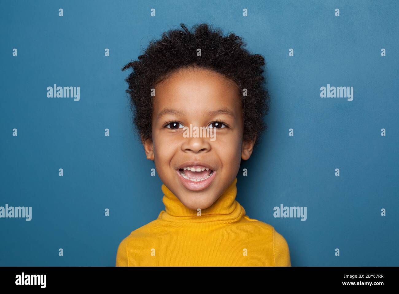 Surprised black kid boy on blue background Stock Photo