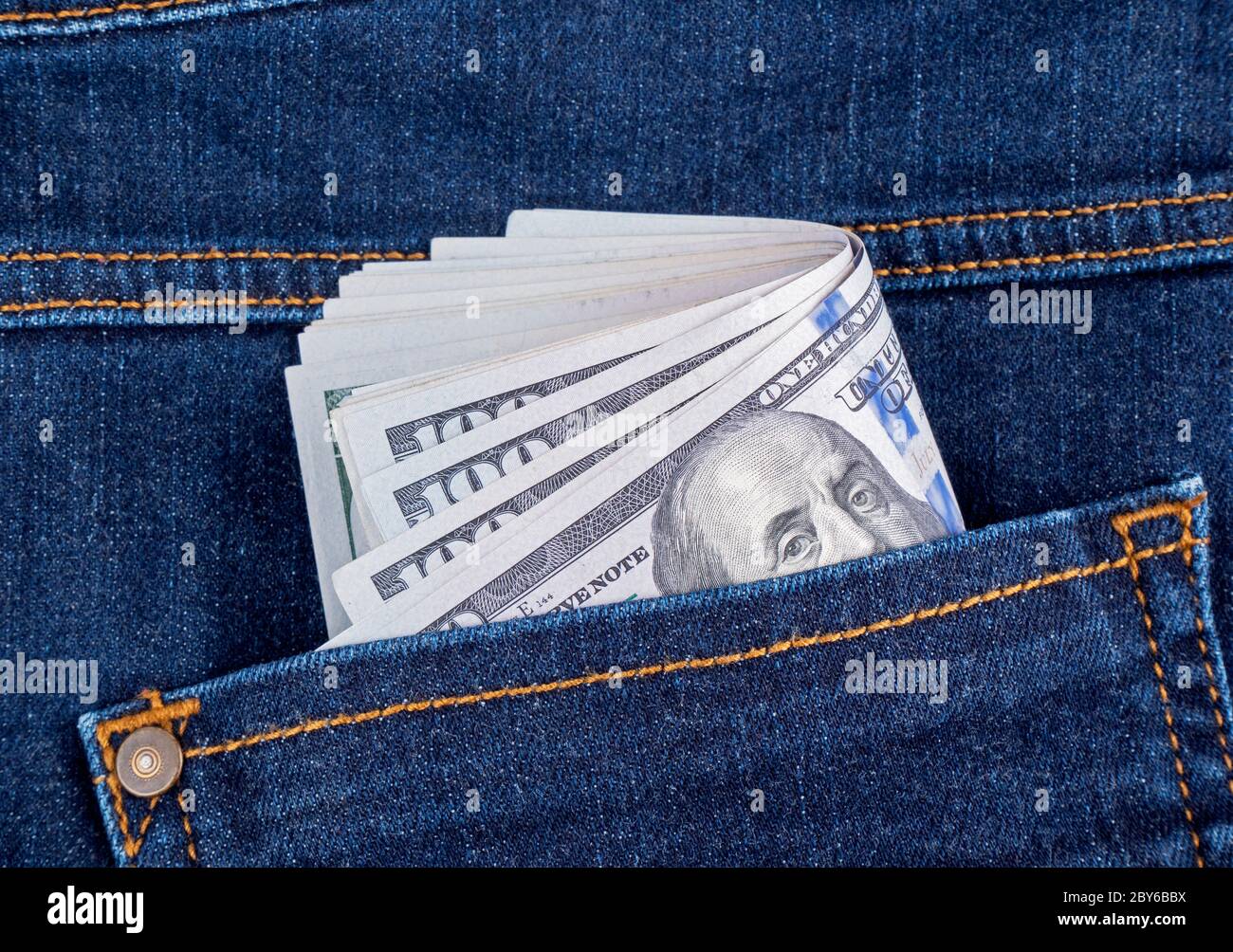 Dollar banknotes in the pockets of jeans trousers Stock Photo