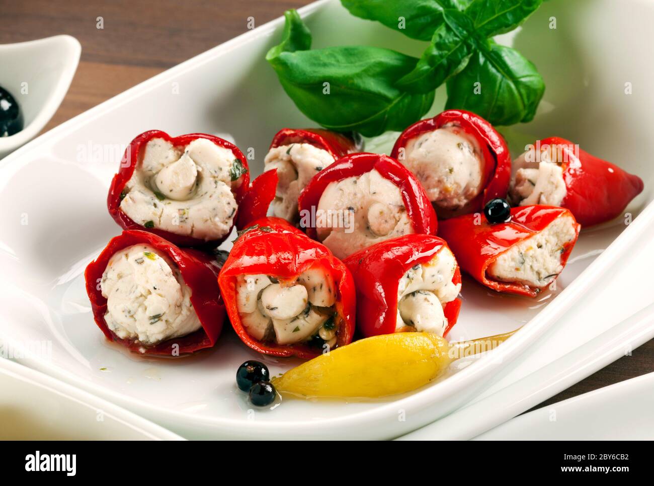 Italian cuisine, antipasti. Closeup of red peppers filled with a cream of goat cheese and herbs Stock Photo