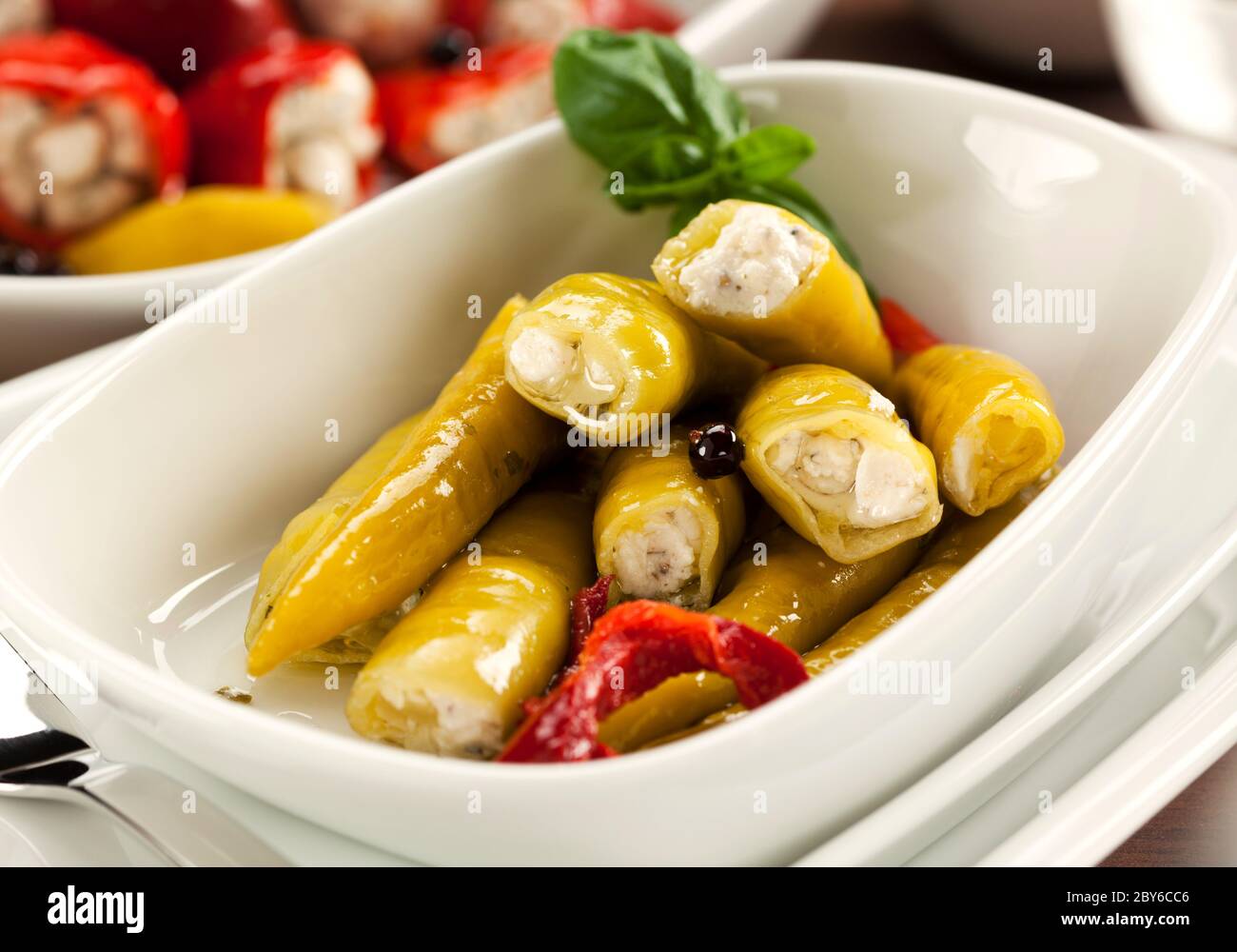 Antipasti, italian cuisine: closeup of green pepperoncini filled with a cream of goat cheese and herbs Stock Photo