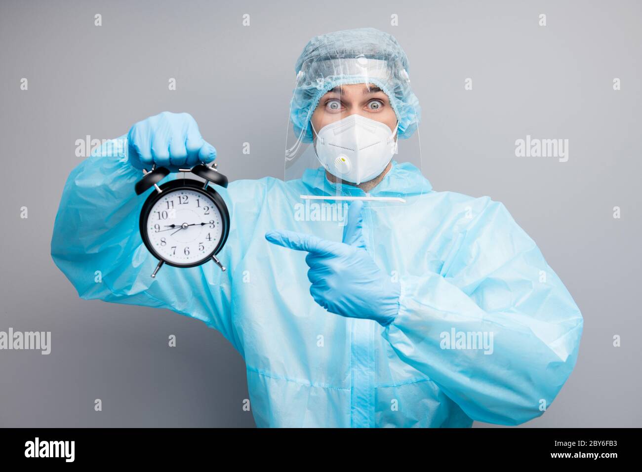Photo of guy doc virology center eyes full fear hold alarm clock oversleep morning operation