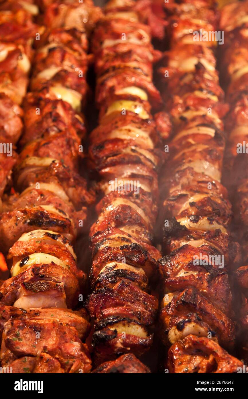 Grilling marinated shashlik on a grill. Shashlik is a form of Shish kebab  popular in Eastern, Central Europe and other places. Shashlyk meaning skewer  Stock Photo - Alamy