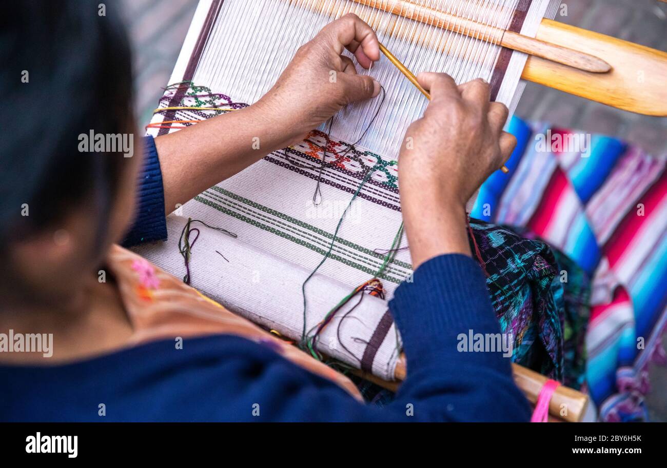 hands weaving a pattern into a scarf Stock Photo