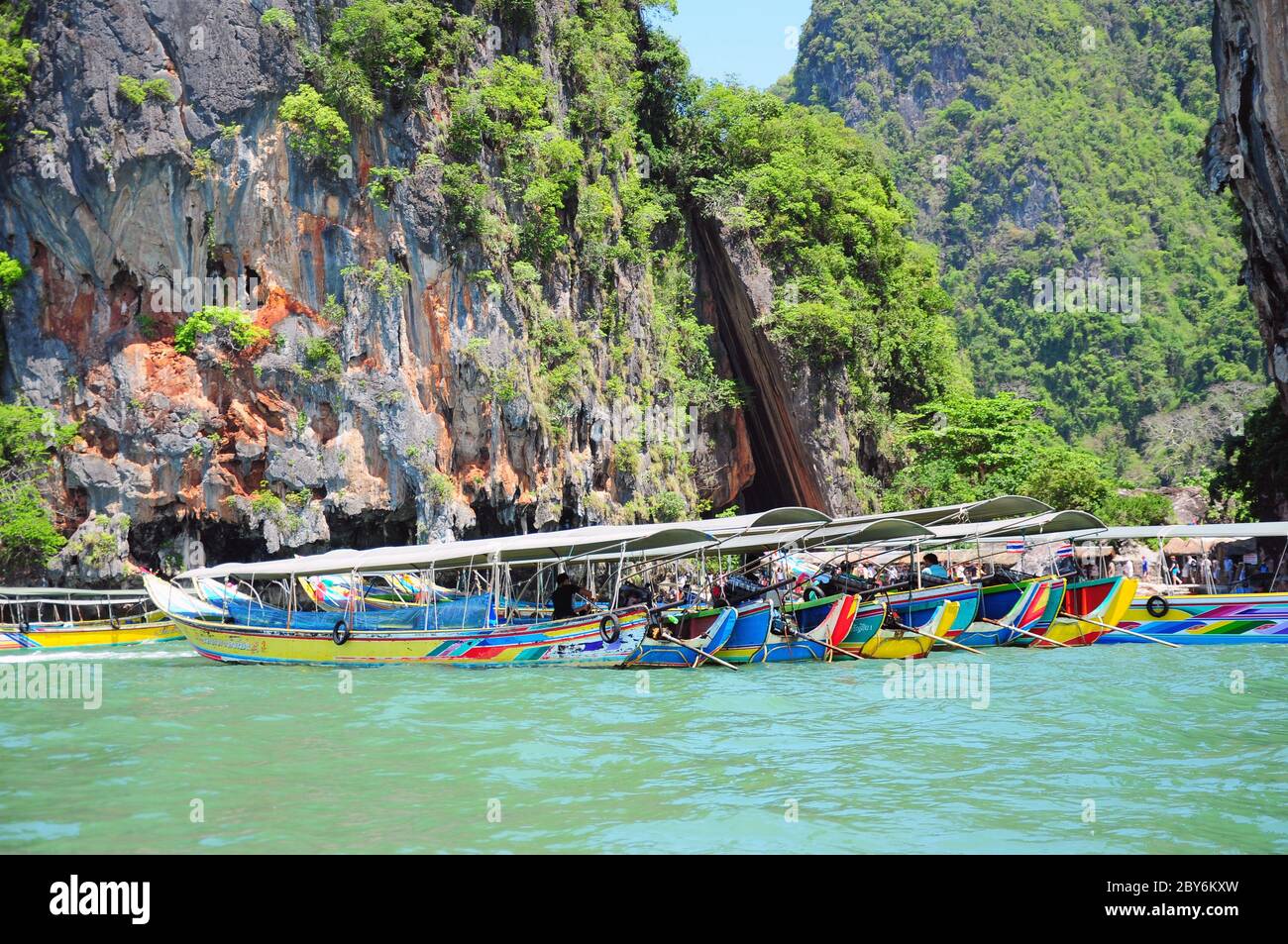 Long-tail boats on rock background. Thailand. Stock Photo