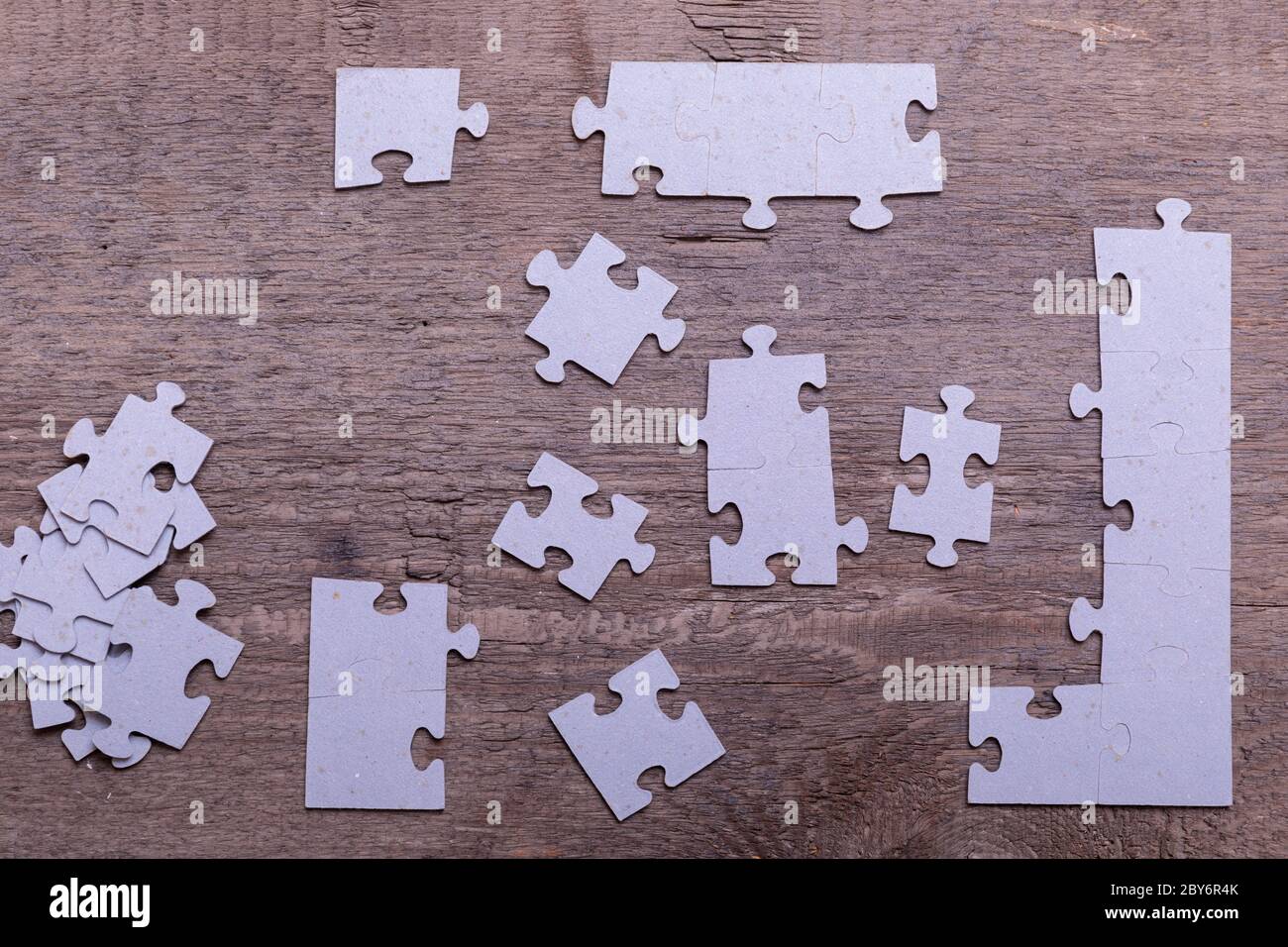 Jigsaw puzzle pieces lying on old wooden rustic boards. Conceptual of innovation, solution finding and integration. Stock Photo