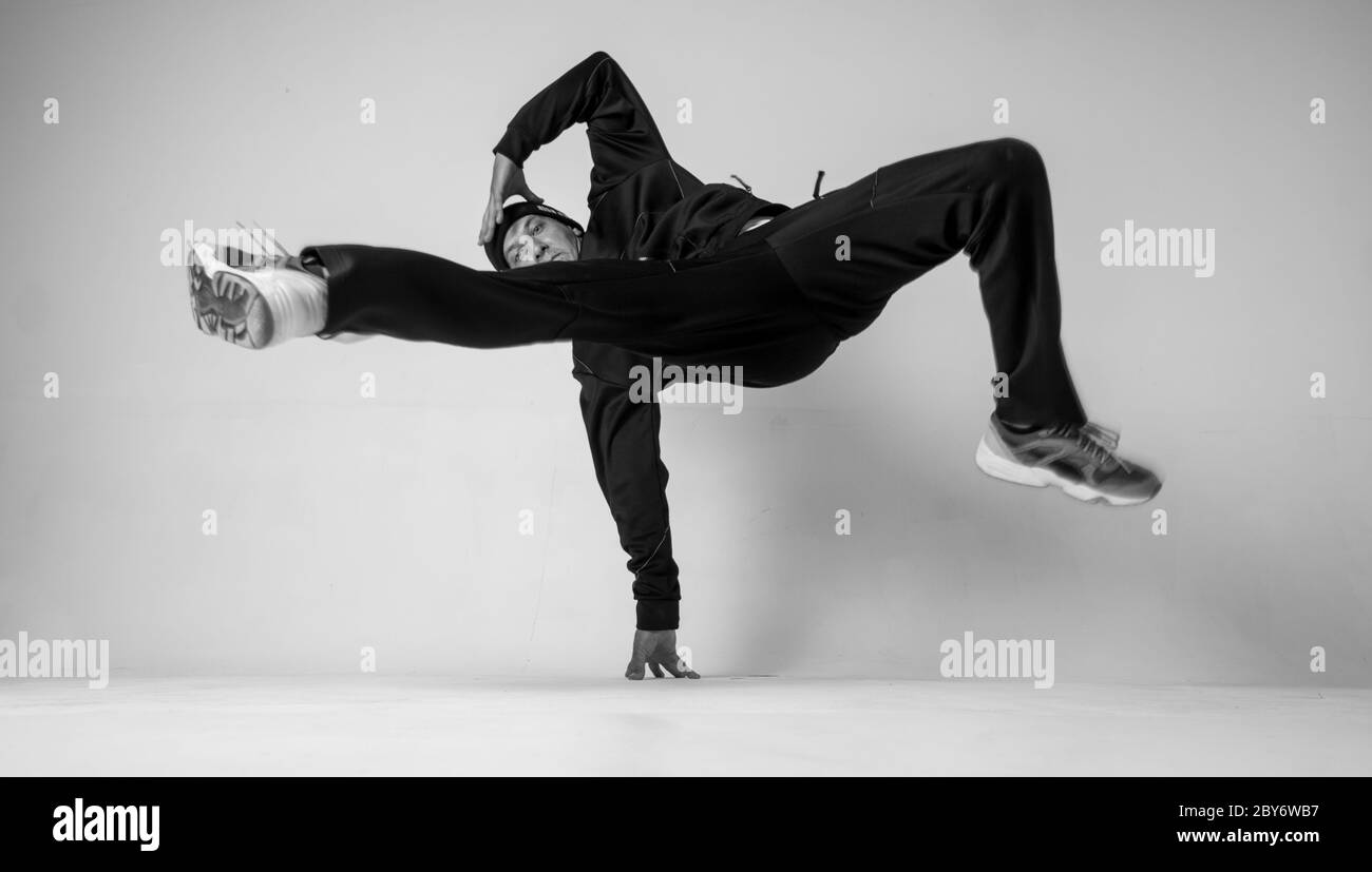 A man hip hop dancer or bboy freezes in one pose on a white background.  Bboy doing stylish stunts Stock Photo - Alamy