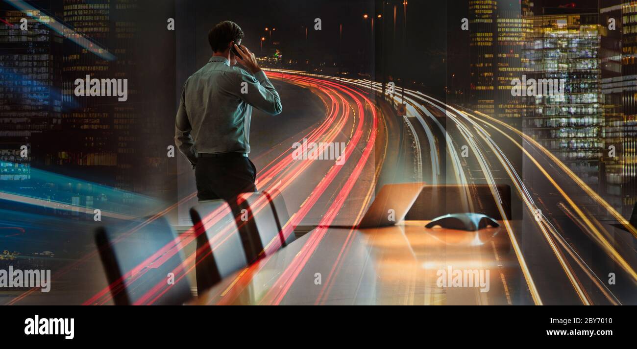 Businessman talking on smart phone in city at night Stock Photo