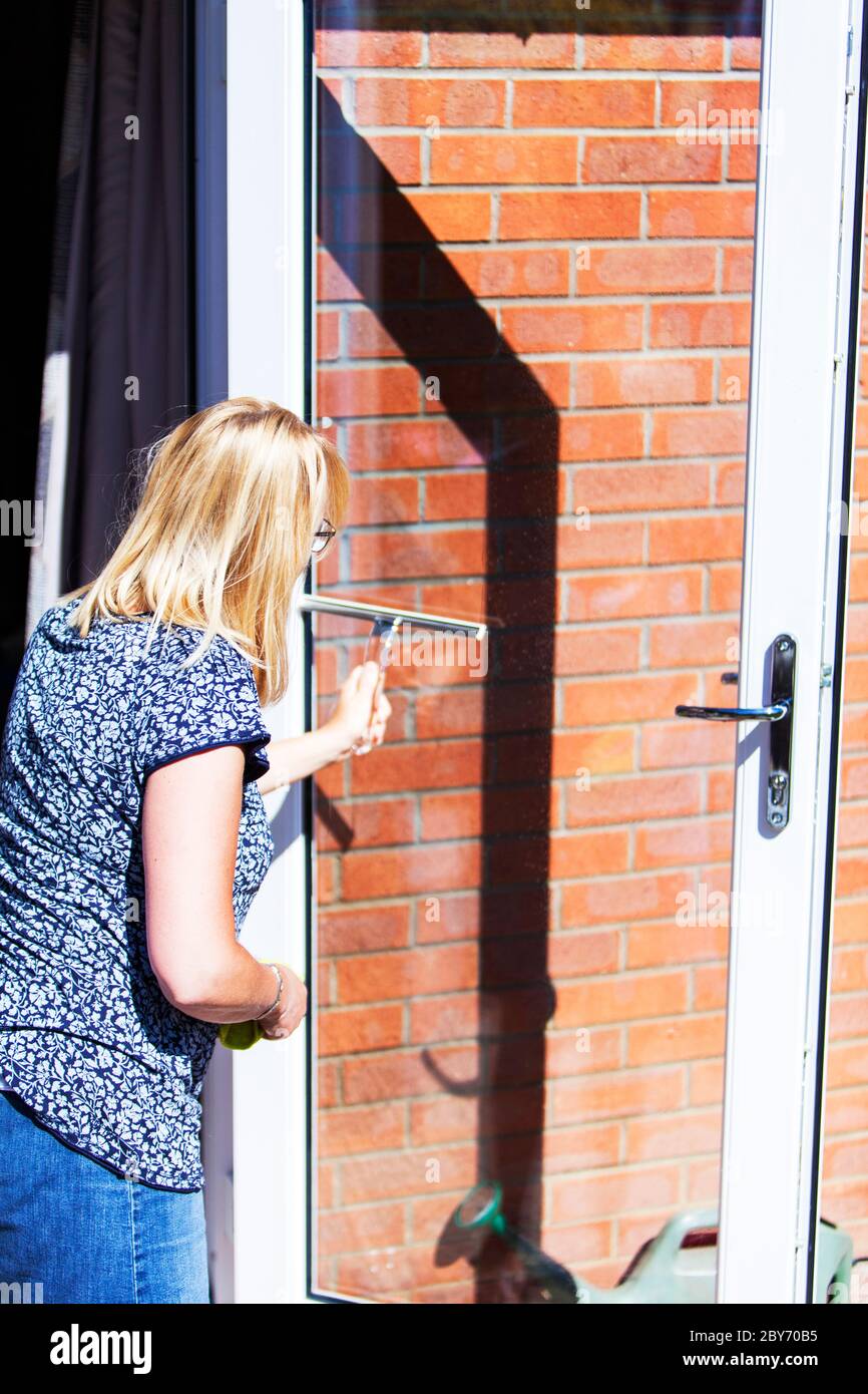 Woman cleaning windows, window cleaner, window cleaning, using squeegee, squeegee, window