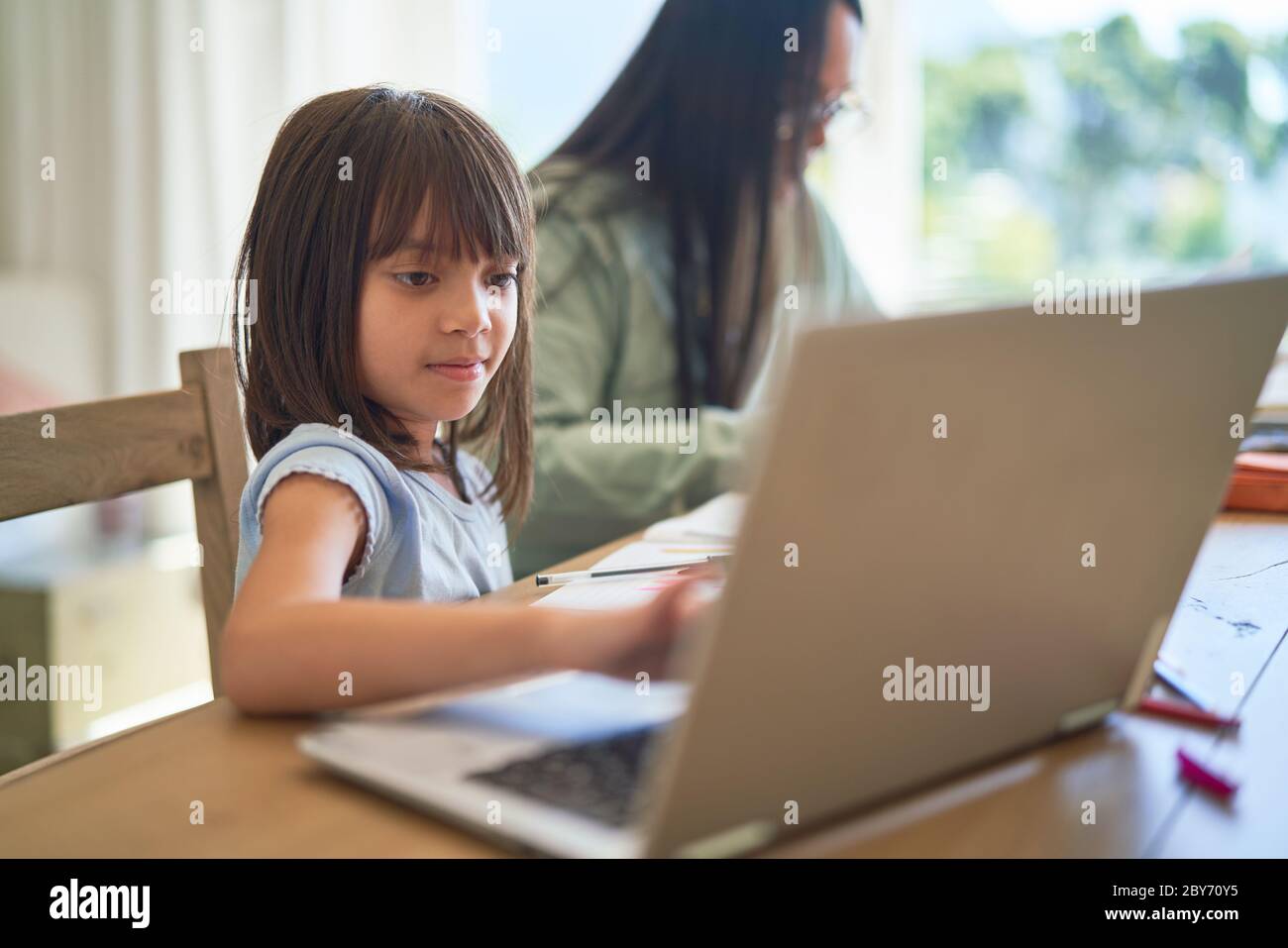 Girl homeschooling at laptop Stock Photo