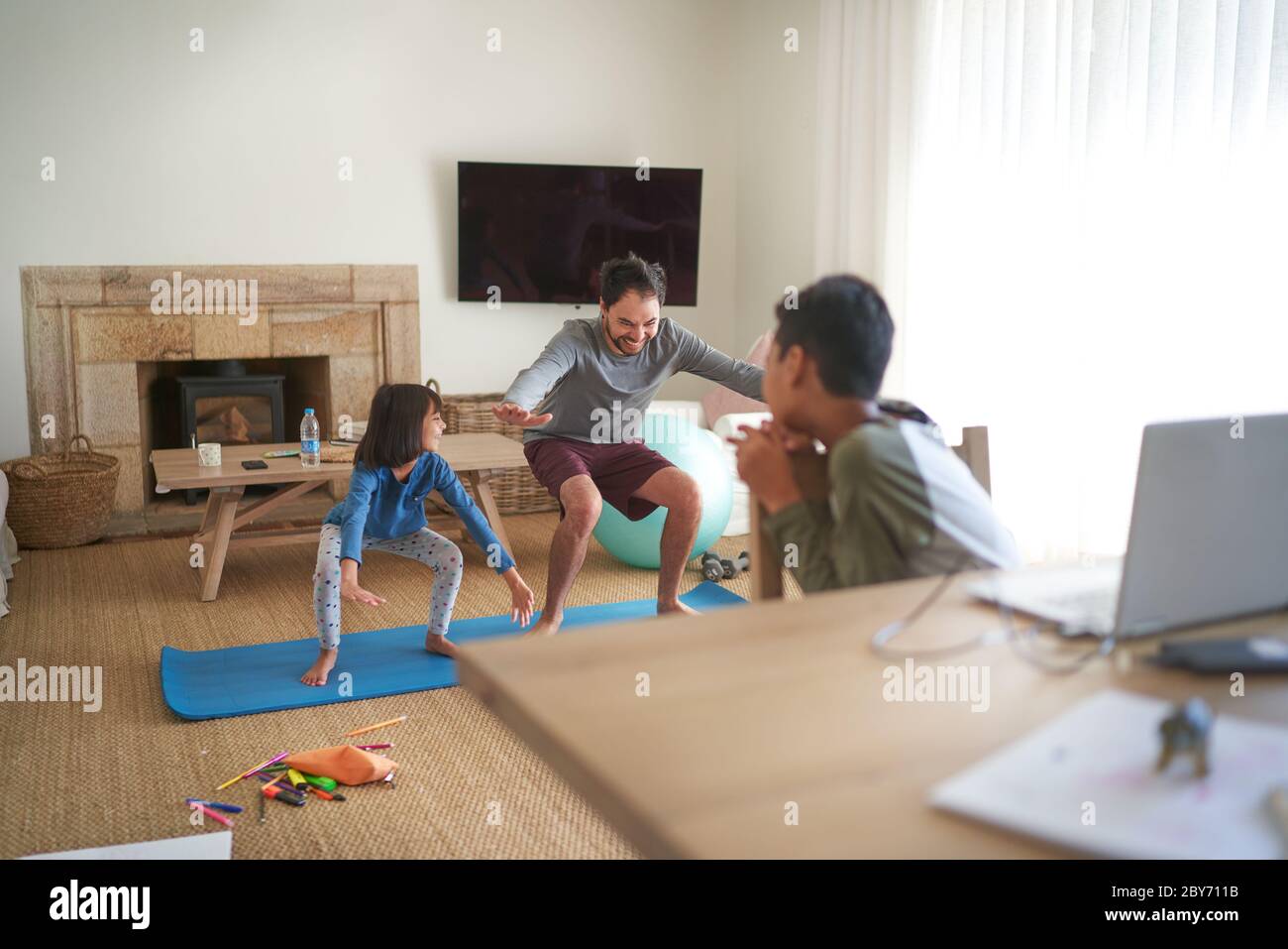 Father and daughter exercising in living room Stock Photo