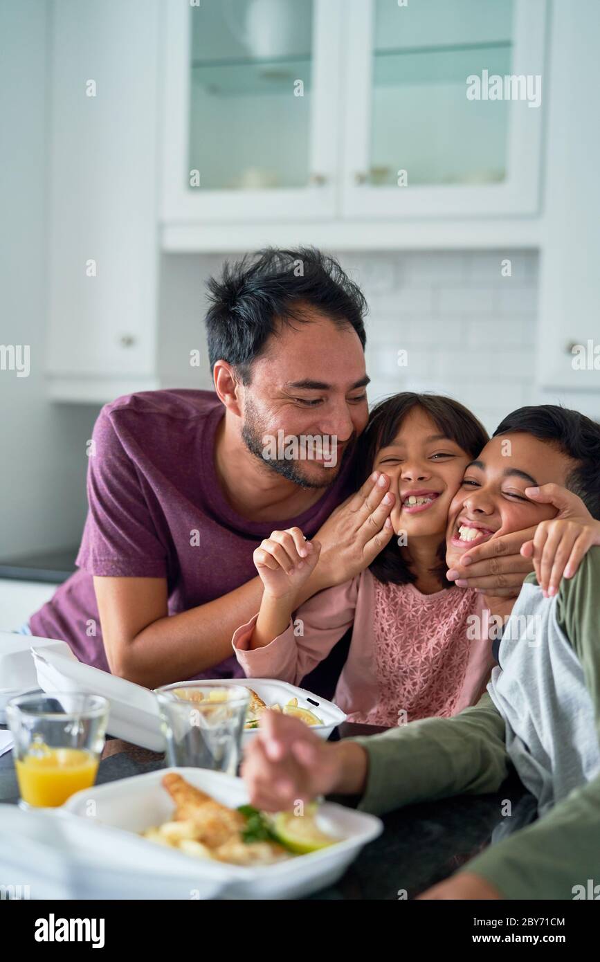 Playful happy family eating take out food in kitchen Stock Photo