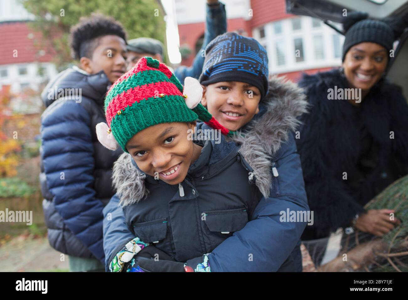Portrait happy brothers in winter coats and hats hugging Stock Photo