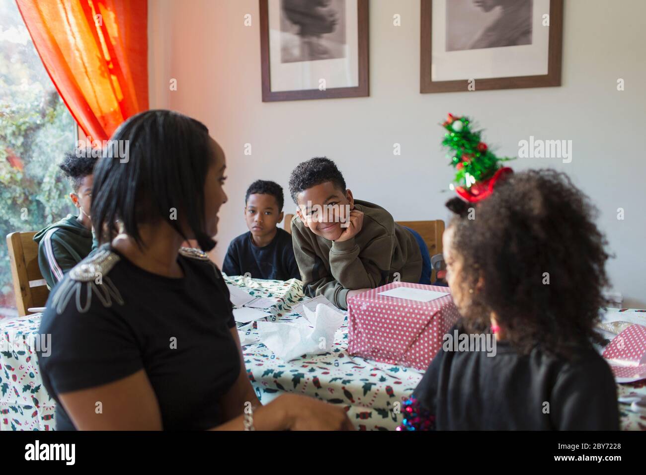 Happy family wrapping Christmas gifts at table Stock Photo