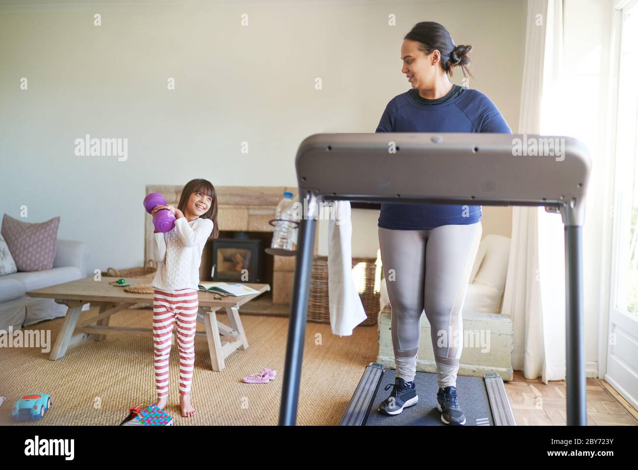 Mother and daughter exercising in living room Stock Photo