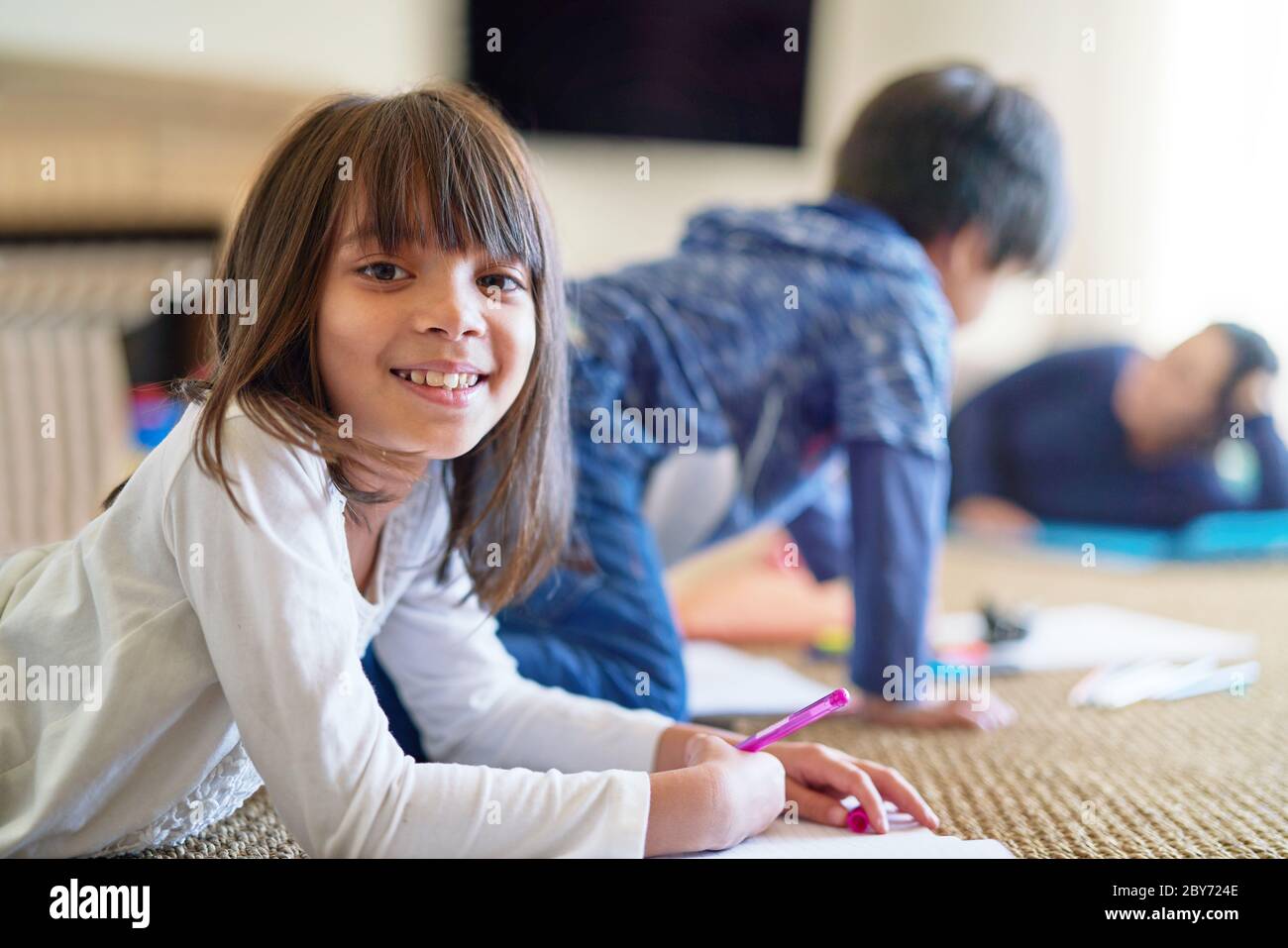 Portrait happy girl coloring on floor Stock Photo