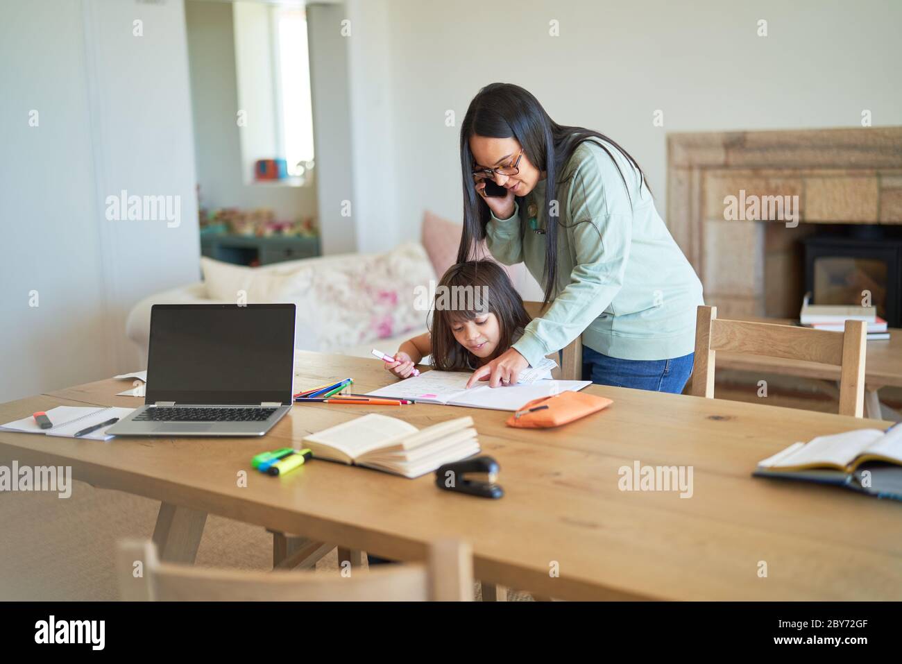 Mother and daughter coloring at dining table Stock Photo