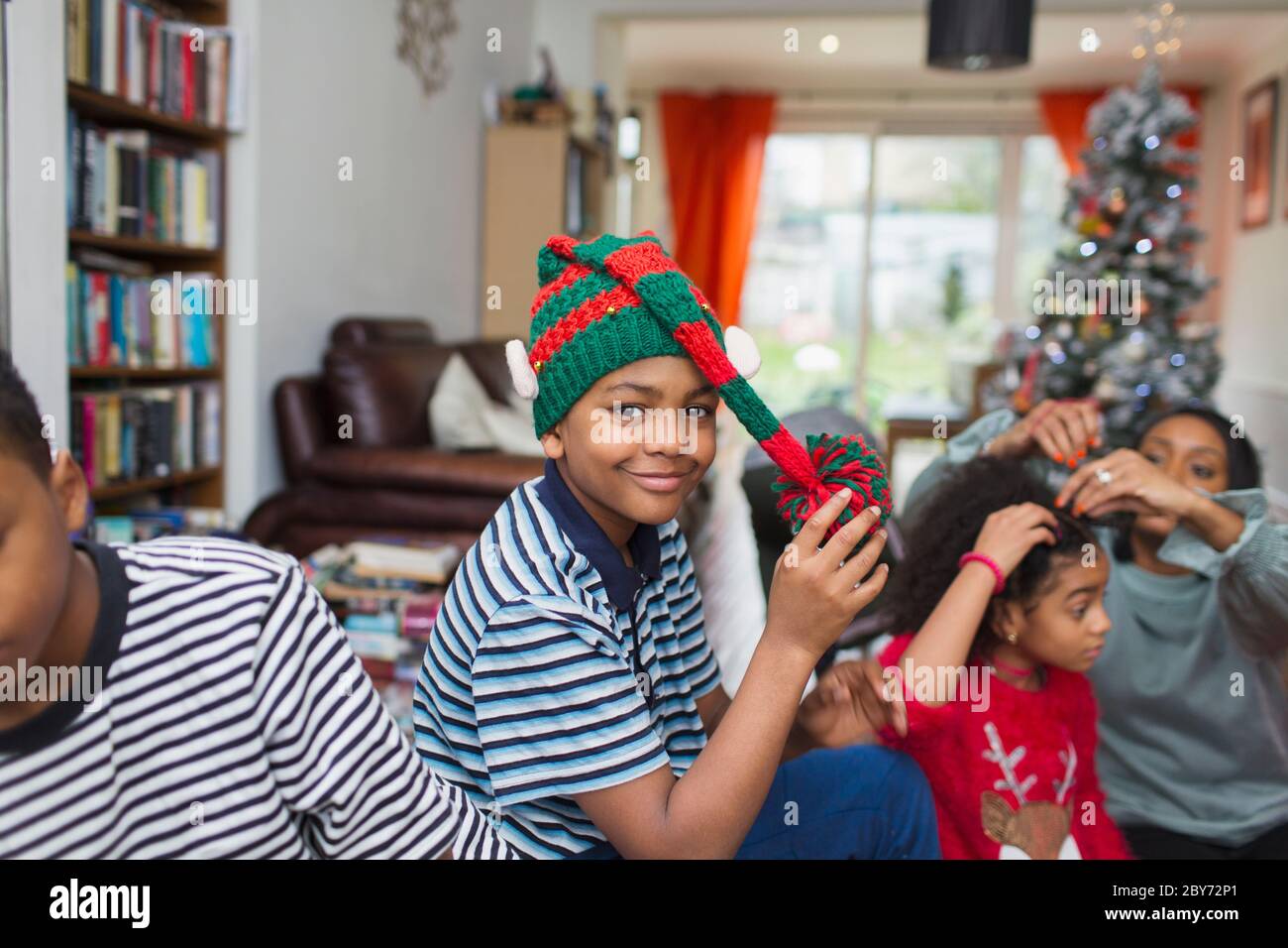 Portrait festive boy wearing Christmas hat in living room Stock Photo
