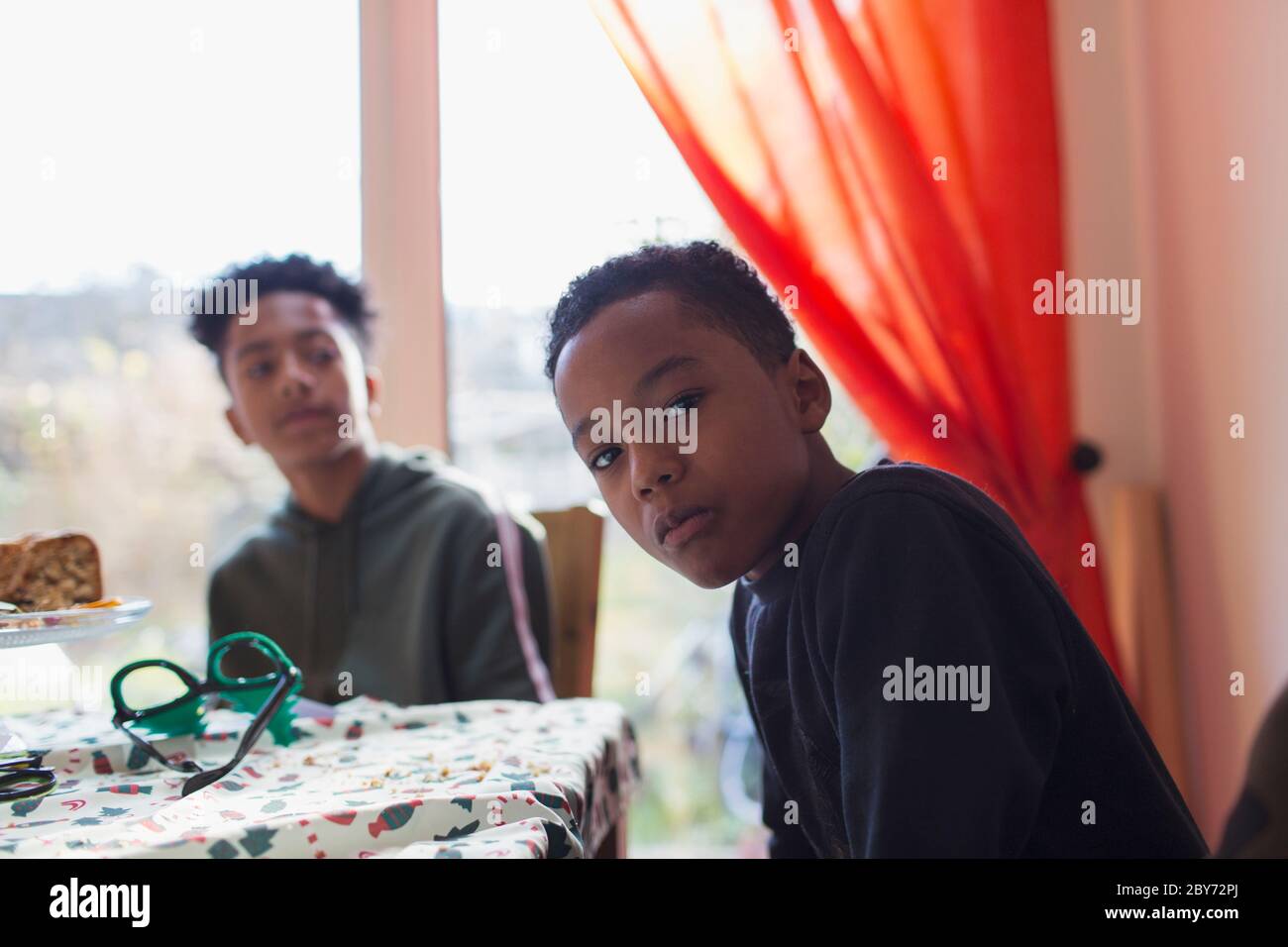 Portrait serious brothers at dining table Stock Photo