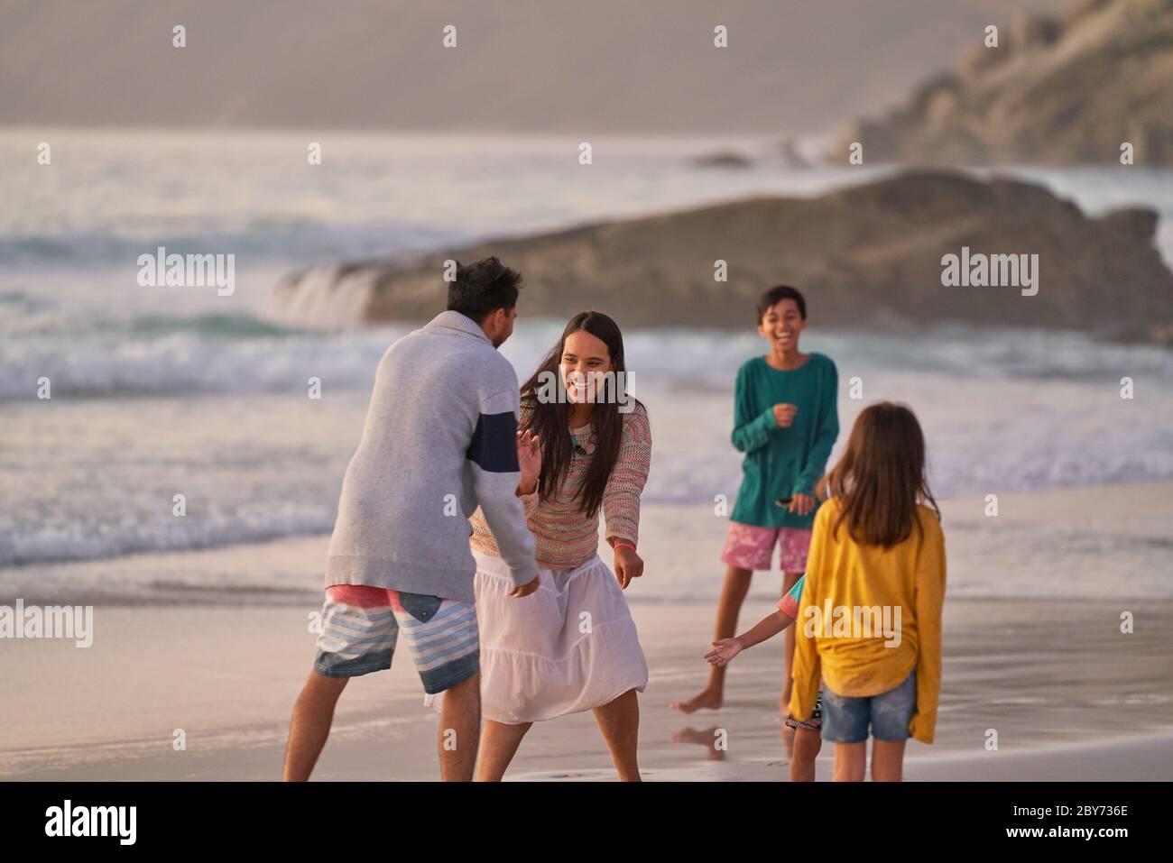 Happy family playing on ocean beach Stock Photo