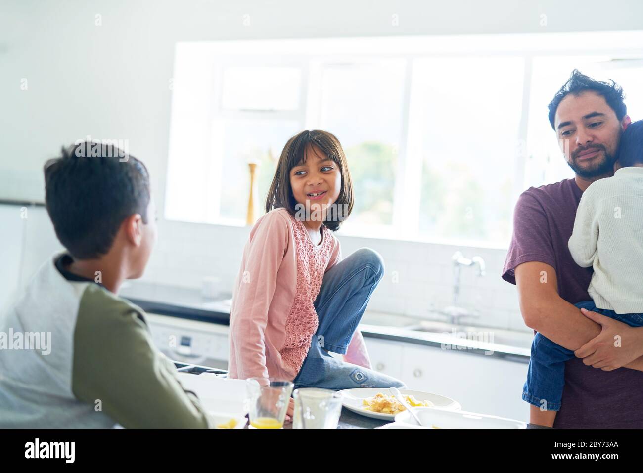 Father and kids eating breakfast in morning kitchen Stock Photo