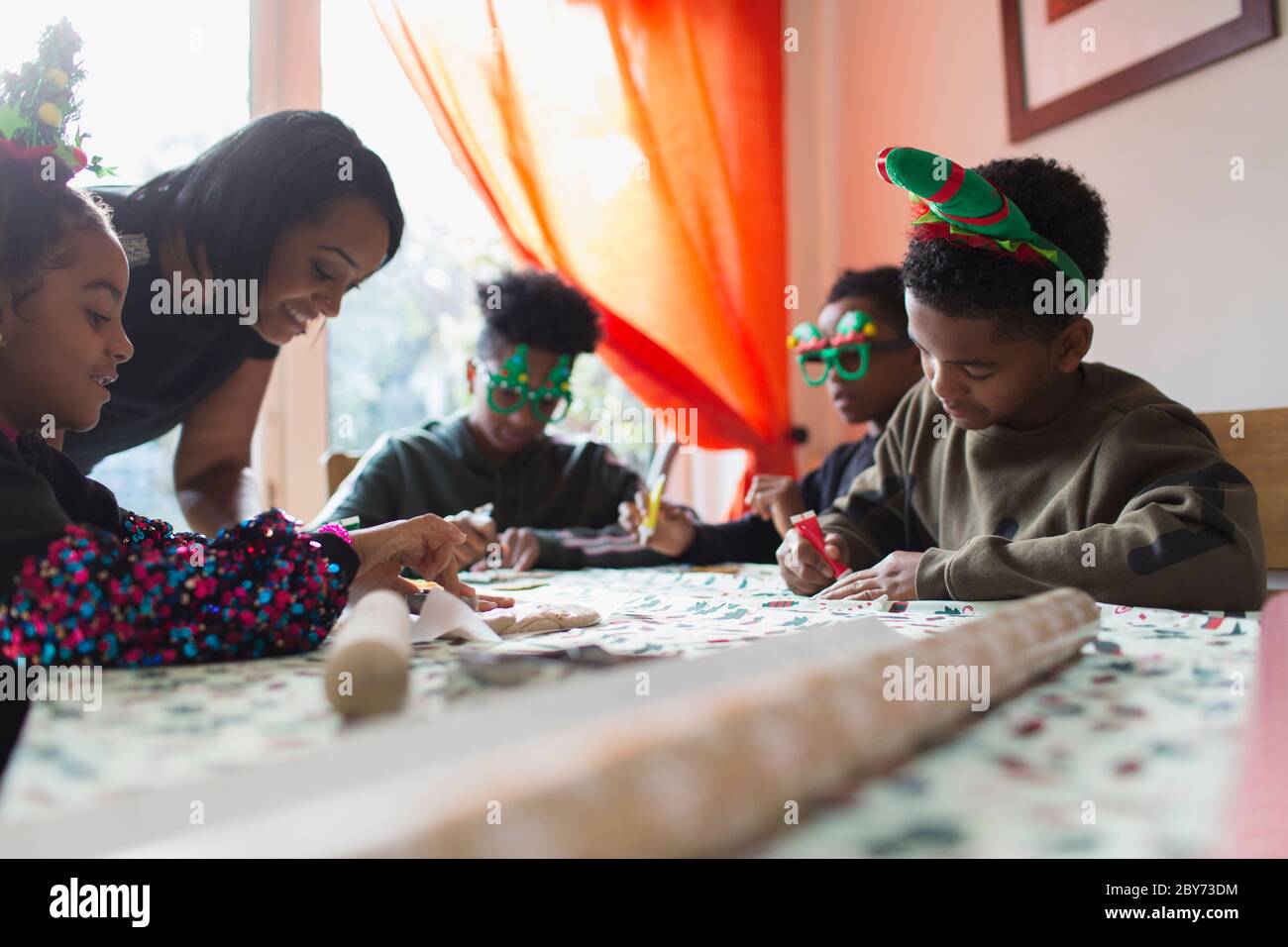 Family decorating Christmas cookies at table Stock Photo