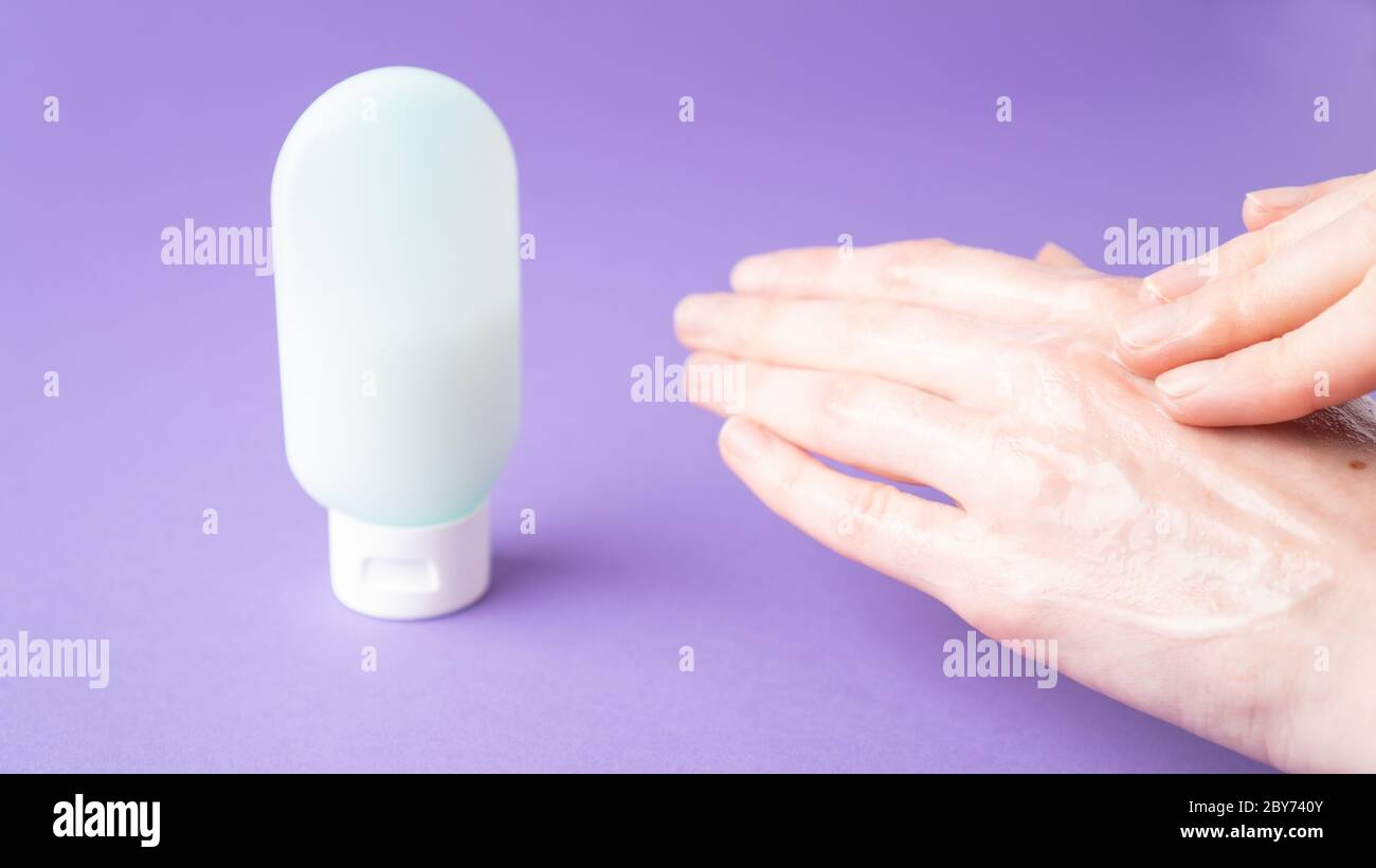 Moisturize hands with lotion. Woman applying moisturizing cream on hands. Body care. Isolated. Hand massage. Stock Photo