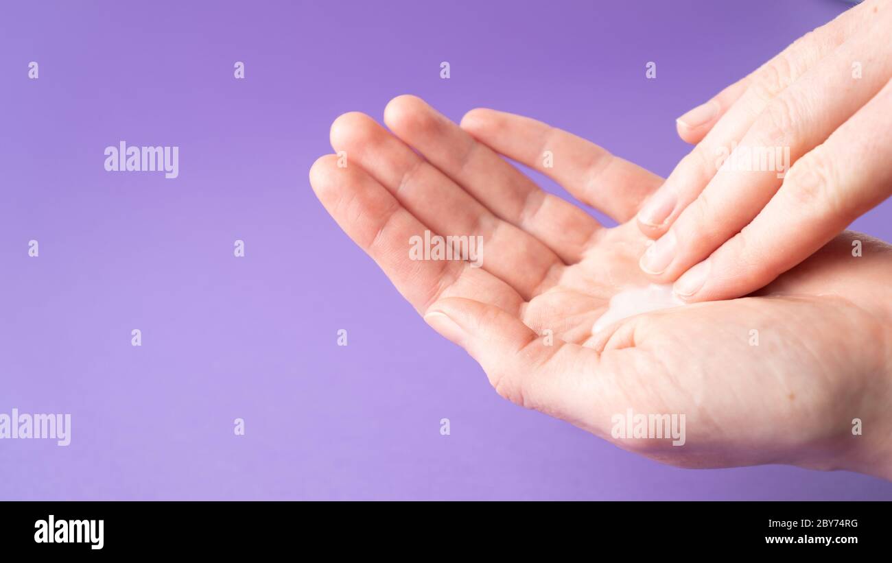 Moisturize hands with lotion. Woman applying moisturizing cream on hands. Body care. Isolated. Hand massage. Stock Photo