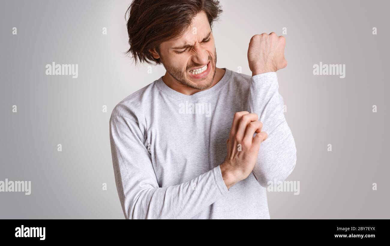 Skin irritation and itching. Man expression of pain, suffers from allergies or insect bites Stock Photo