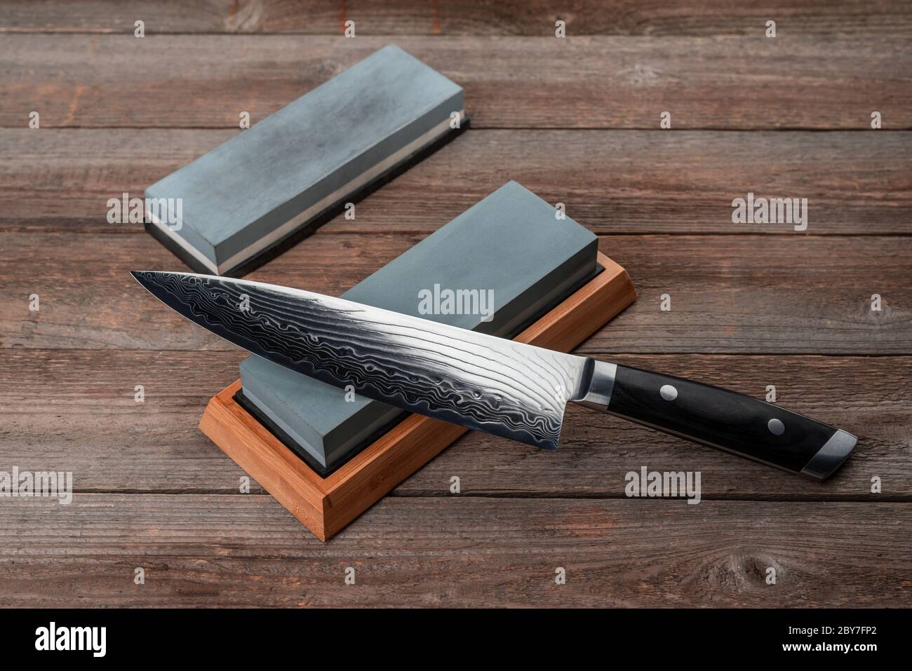 Chef's knife and whestones on rustic wooden background Stock Photo Alamy