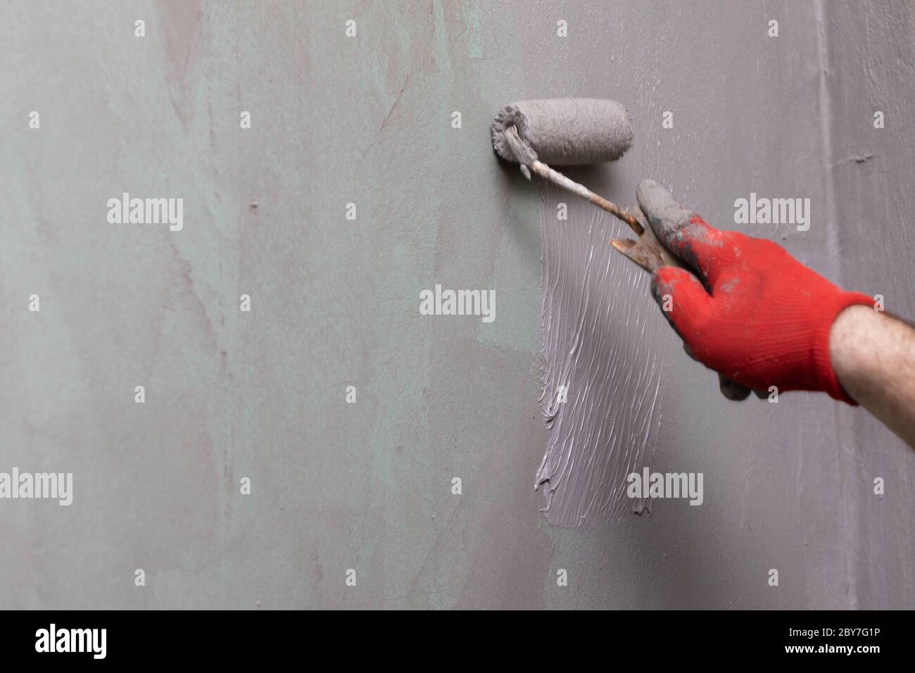Closeup of an experienced construction worker applying damp insulation