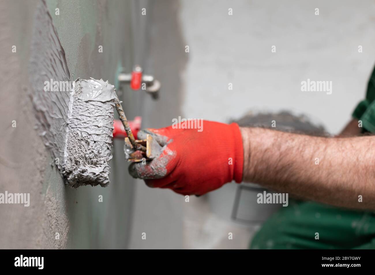 Closeup of an experienced construction worker applying damp insulation