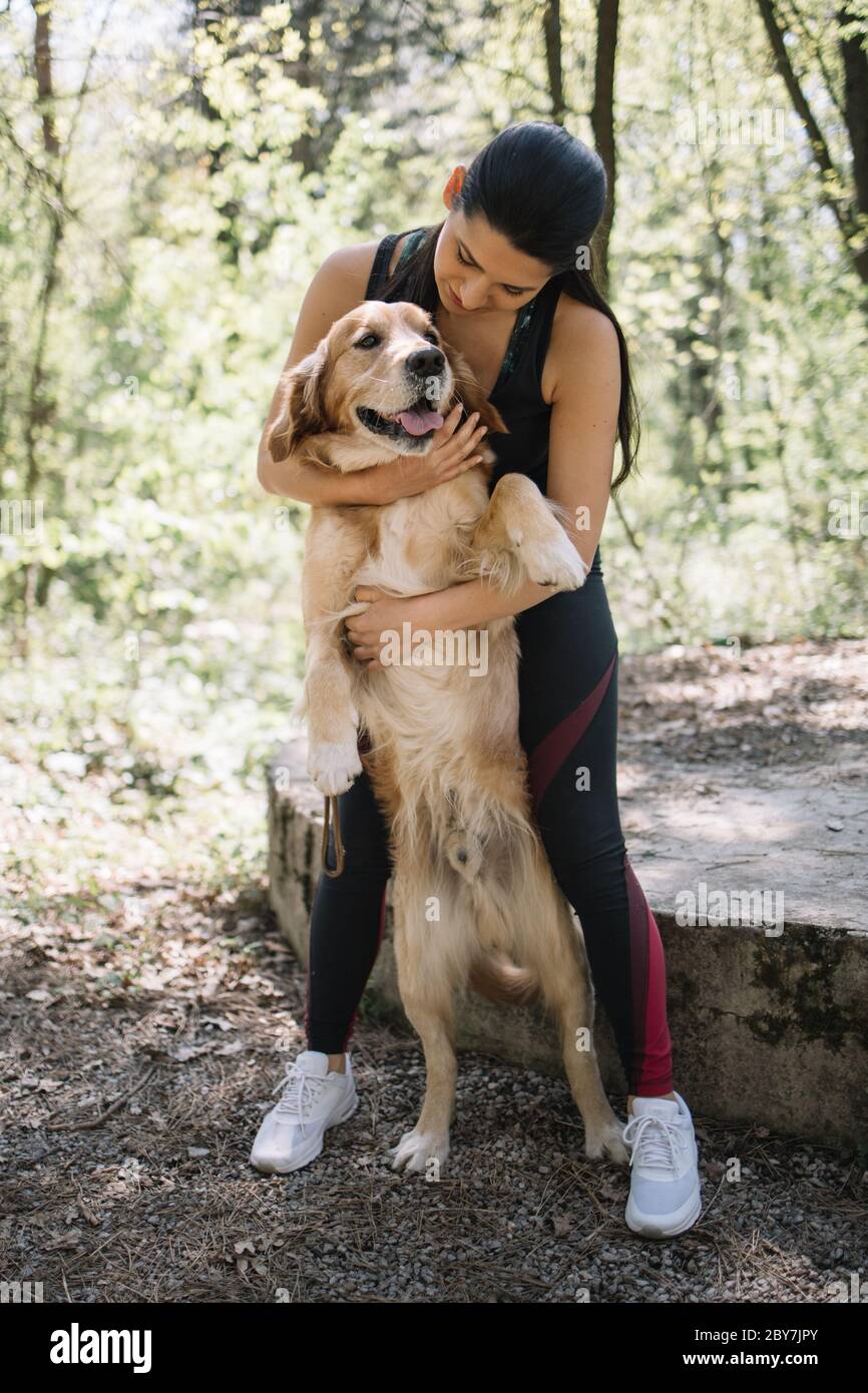 Young woman in park with her golden retriever dog Stock Photo - Alamy