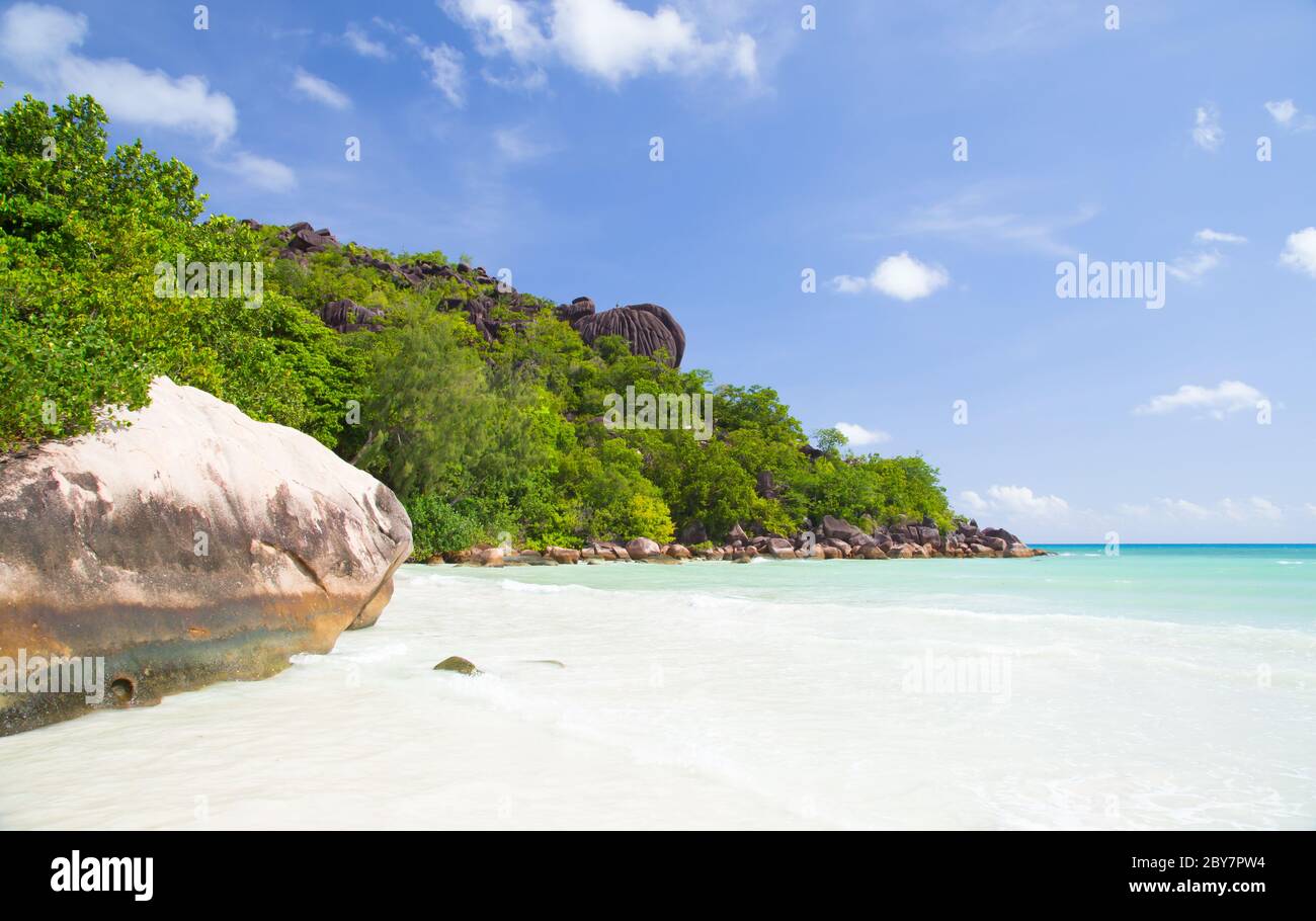 Beach with blue water and blue sky and white sand and some rocks Stock ...