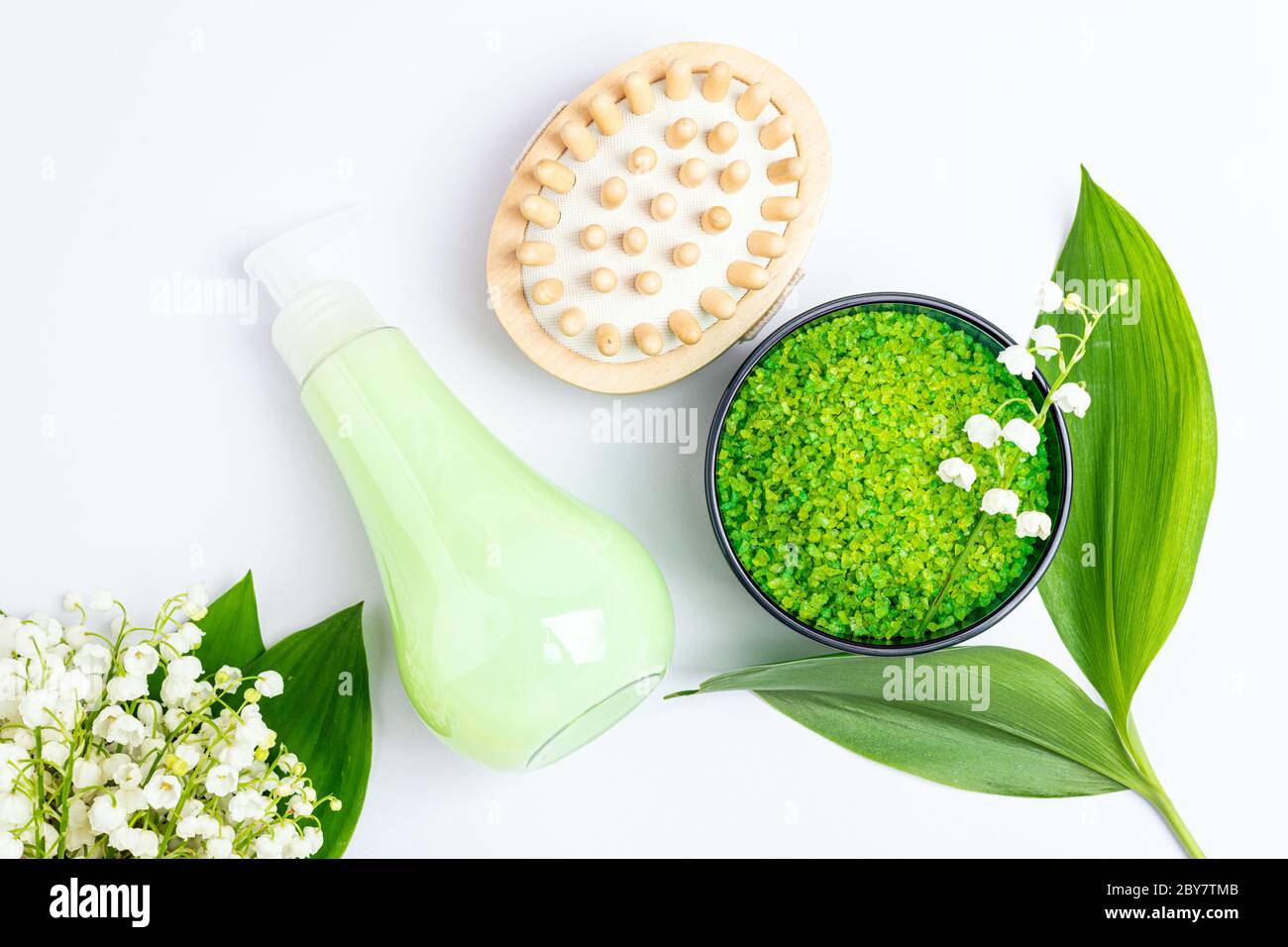 Spa treatment wellness concept. Natural spa cosmetics products and accessories, massage brush, soap, herbal sea salt, flowers on white background. Spa Stock Photo