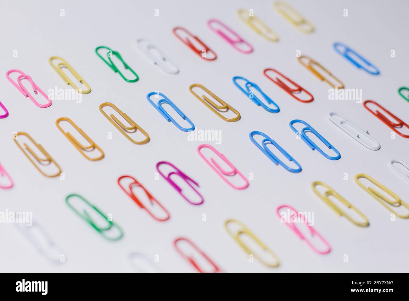 multicolored paper clips on white background Stock Photo