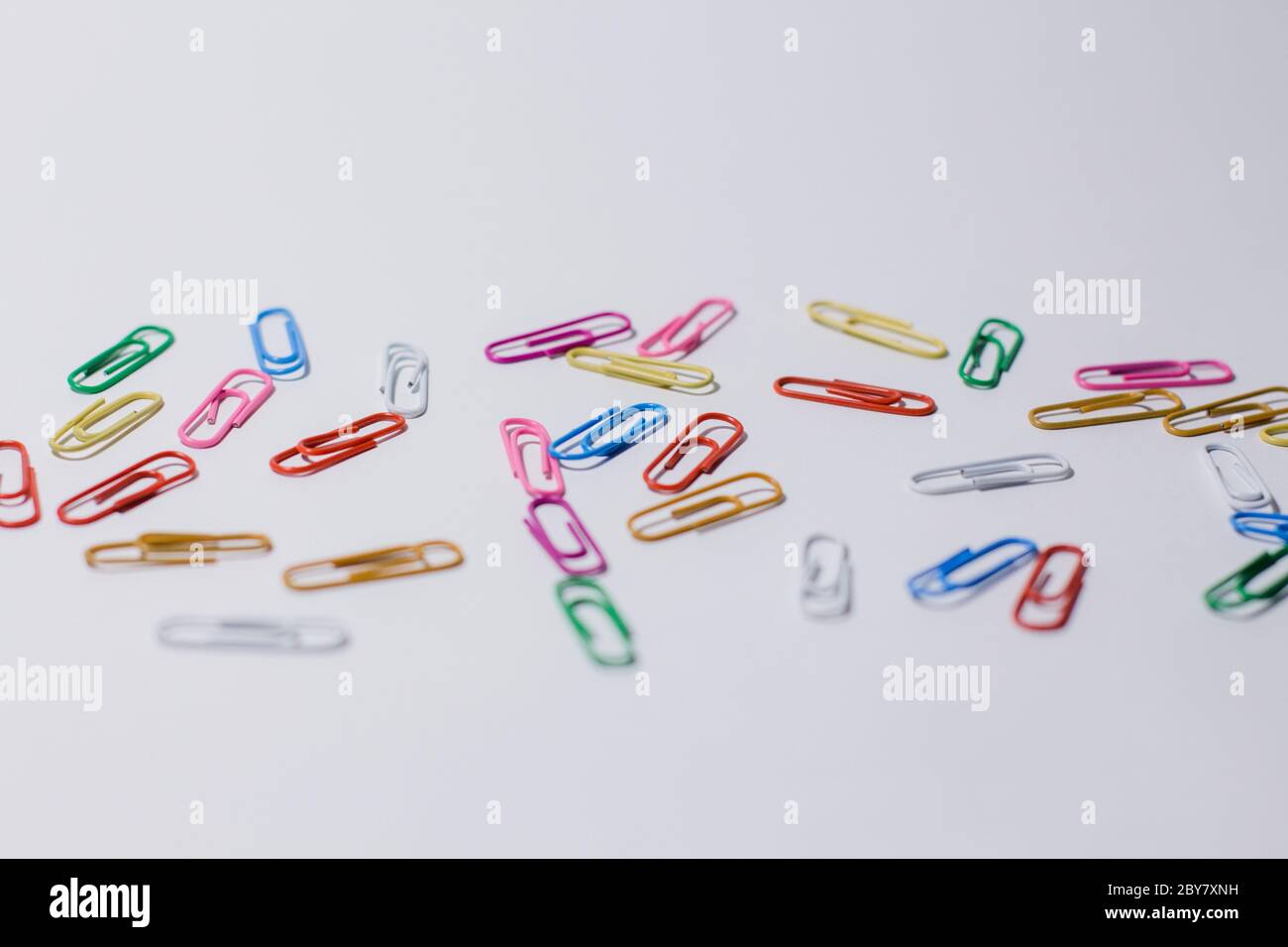 multicolored paper clips on white background Stock Photo