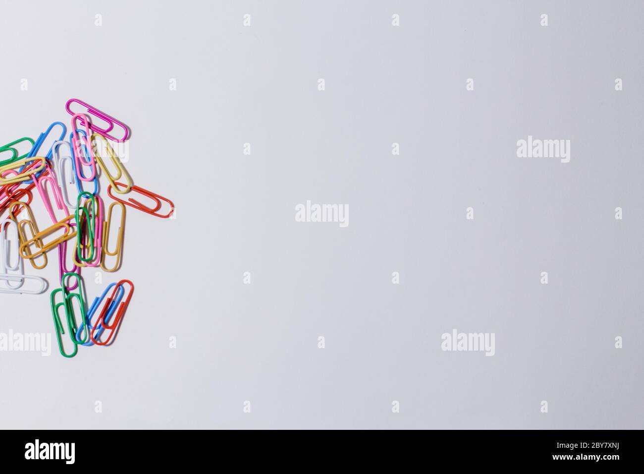 multicolored paper clips on white background Stock Photo