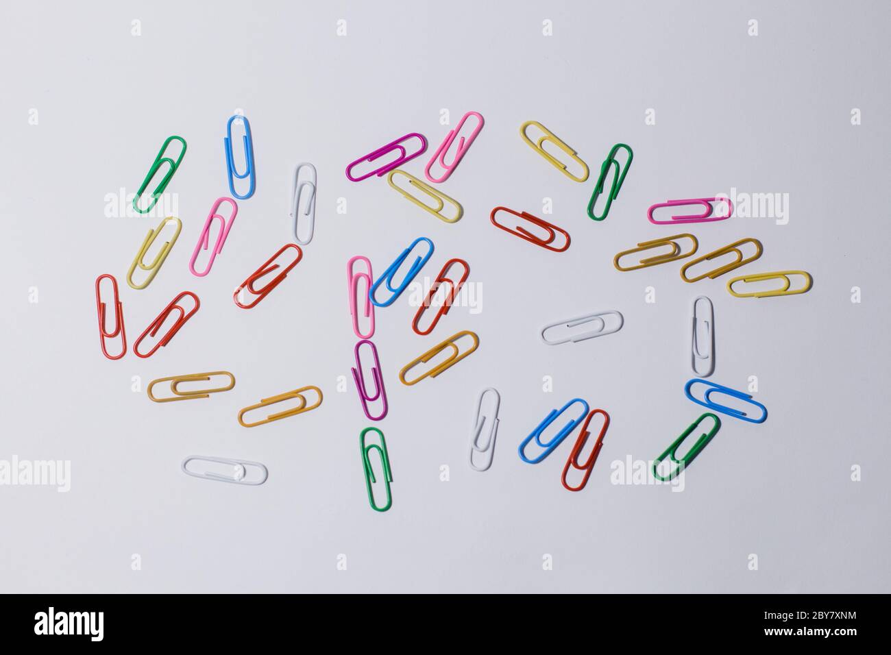 multicolored paper clips on white background Stock Photo